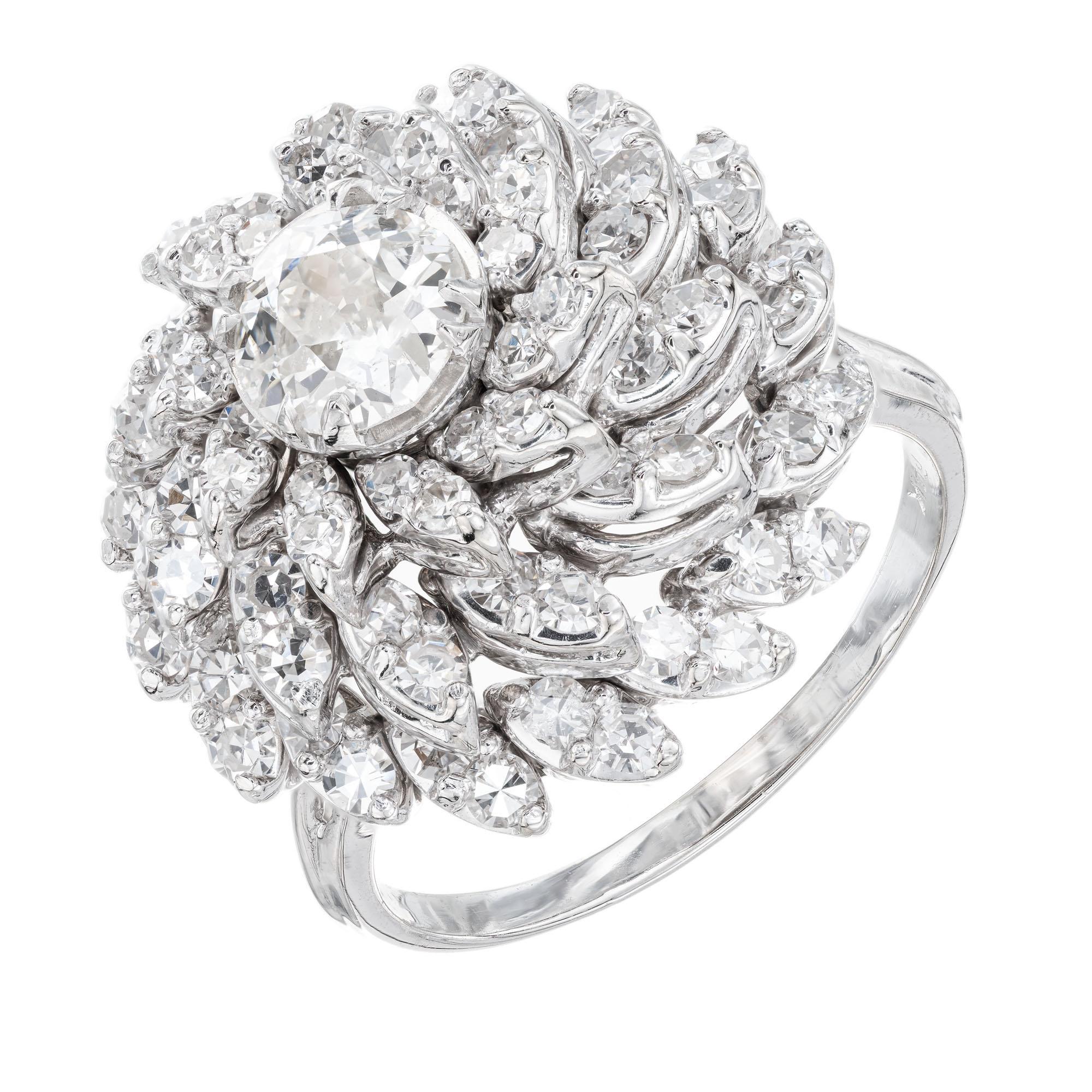 Diamond domed cocktail ring. Old European cut .94ct center stone accented with three tiers of round cut diamonds in 14k white gold petals and setting.  14k white gold. Raised spiral design circa early 1900's.

1 Old European diamond, I-J I-I approx.