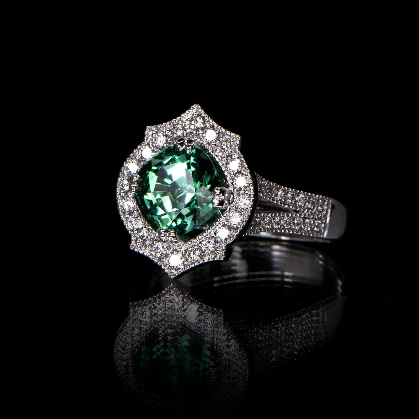 Part of the brand new 'Mauresque' collection by Natalie Barney, this cluster engagement ring features a 2.59 carat Namibian Green Cushion Cut Tourmaline and 52 round white diamonds with a total weight of 0.46 carat (Colour F, Clarity VS). The