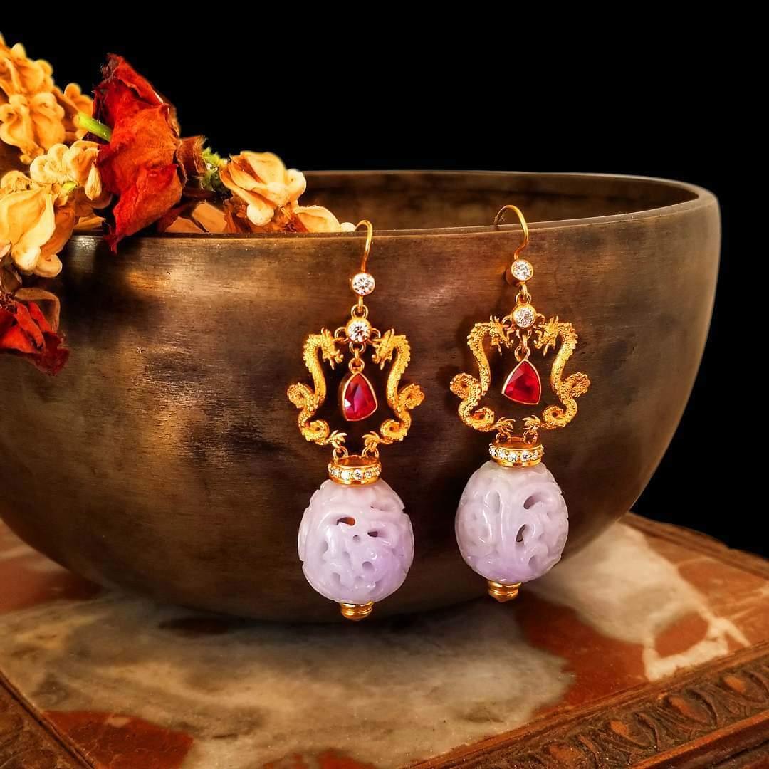 These One of a Kind Elegant Earrings in 18 Karat Yellow Gold feature Intricately Designed Apposing Dragons with extraordinary 360 degree detail and dancing movement. The Dragons face a Very Fine AAA Red Ruby on each ear. The dangling Ruby is a deep
