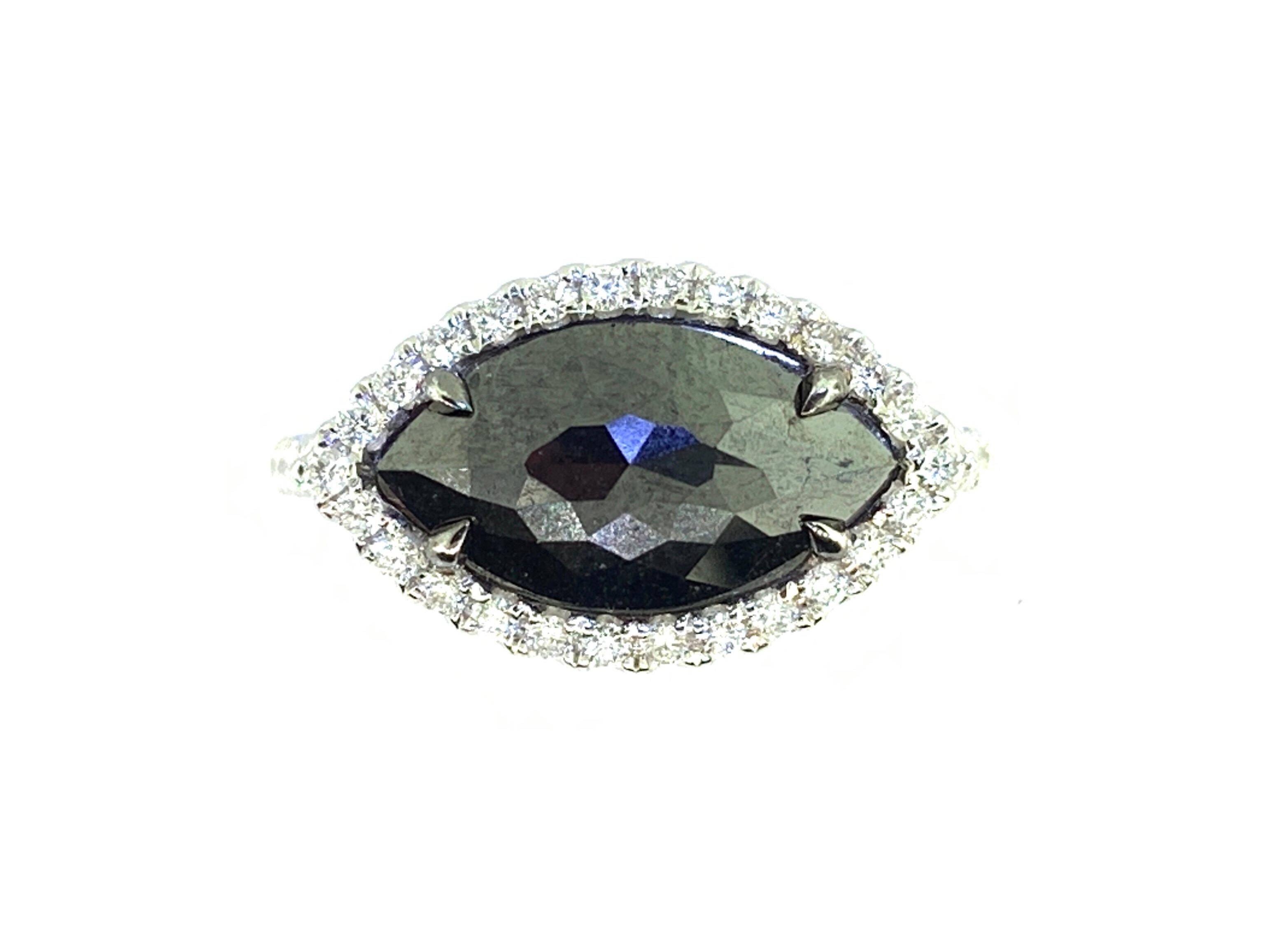 This stunning cocktail ring features a 2.59 Carat Rose Cut Marquise Black Diamond with a White Diamond Halo. The Black Diamond sits on a diamond shank and is set in 18k white gold. 
Total Diamond Weight (not including center stone) = 0.47 carats.