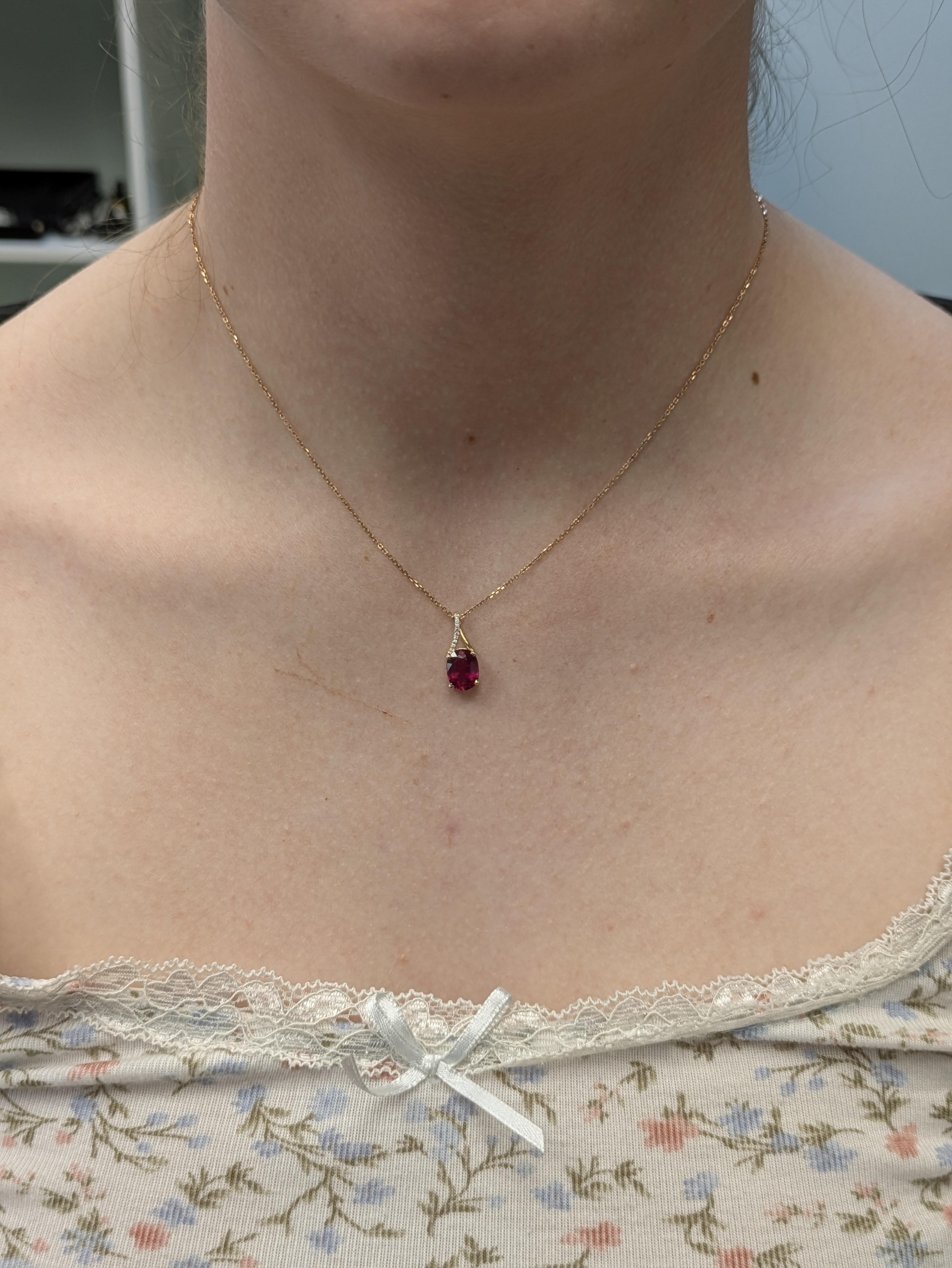 Eleganter Anhänger aus 14-karätigem Gold mit einem ovalen Madagaskar-Rubin von 2,6 Karat (9 x 7 mm), der für seine satte Farbe und seine außergewöhnliche Härte von 9 geschätzt wird. 10 zarte Diamanten von insgesamt 0,03 Karat verleihen diesem