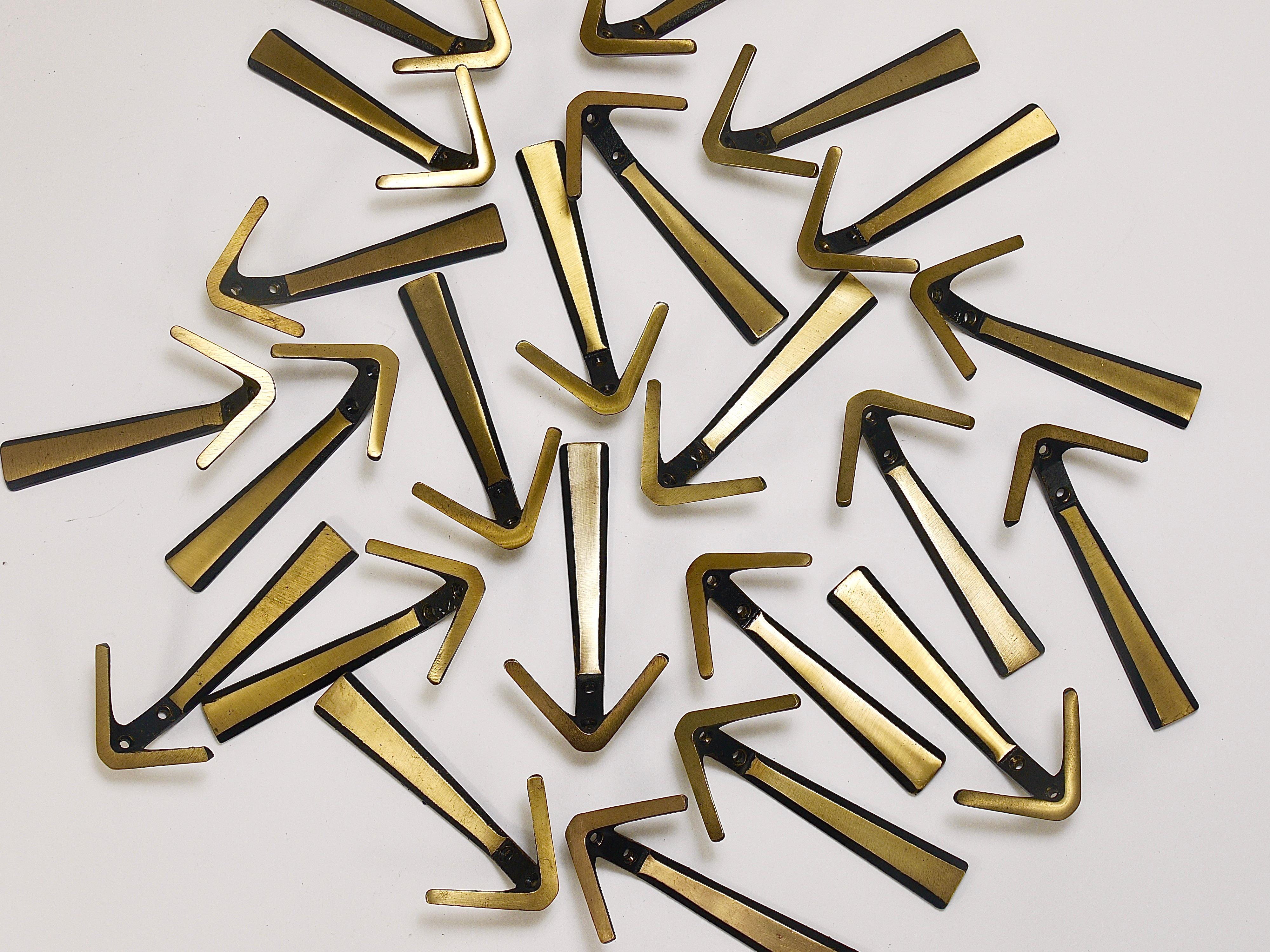 Up to 27 beautiful Austrian modernist V-shaped brass double wall hooks, manufactured in the 1950s by Hertha Baller in Vienna / Austria. Made of black finished and partly brushed brass, solid pieces in very good condition with marginal patina. We