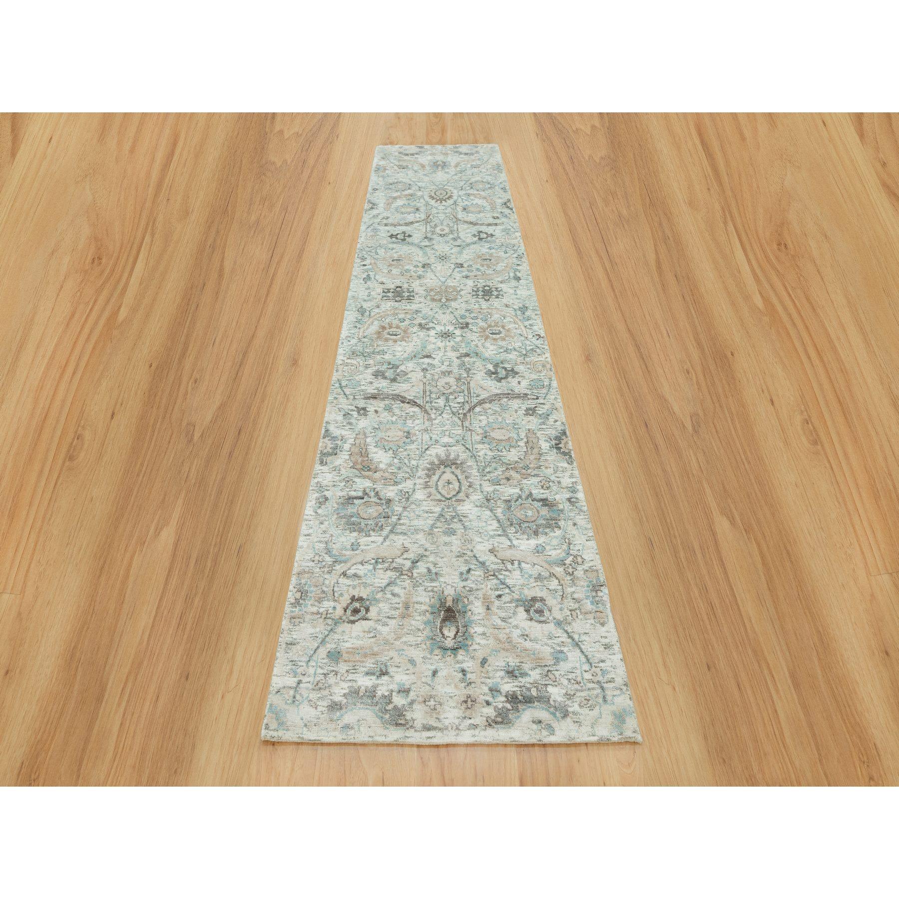 Il s'agit d'un véritable tapis d'Orient en ivoire, à motif de feuilles de faucille, à poils souples, en soie et laine texturée, noué à la main. Il a été noué pendant des mois et des mois selon des techniques de tissage séculaires par des artisans