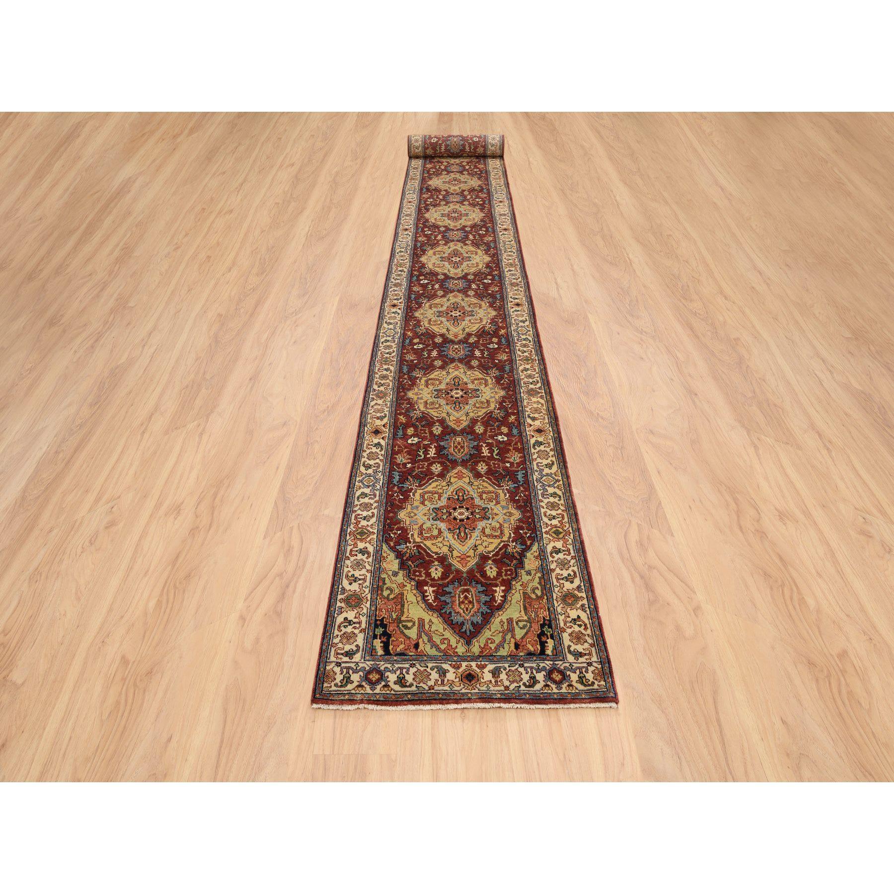 Il s'agit d'un véritable tapis d'Orient, unique en son genre, de couleur rouge terre cuite, avec des motifs anciens de Heriz, densément tissé avec des teintures naturelles, en laine filée à la main, noué à la main, avec une longueur XL. Il a été