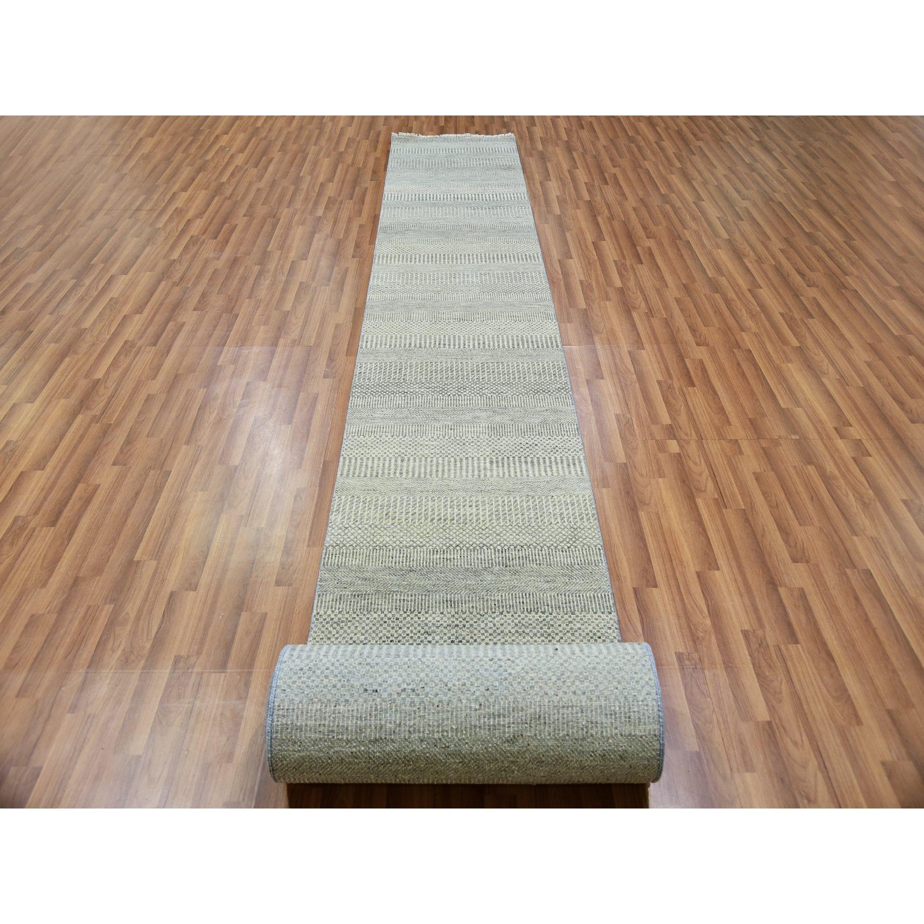 Il s'agit d'un véritable tapis d'Orient en pure laine non teintée, ton sur ton, au design moderne de graminées, noué à la main. Il a été noué pendant des mois et des mois par des artisans selon des techniques de tissage séculaires.
Matières