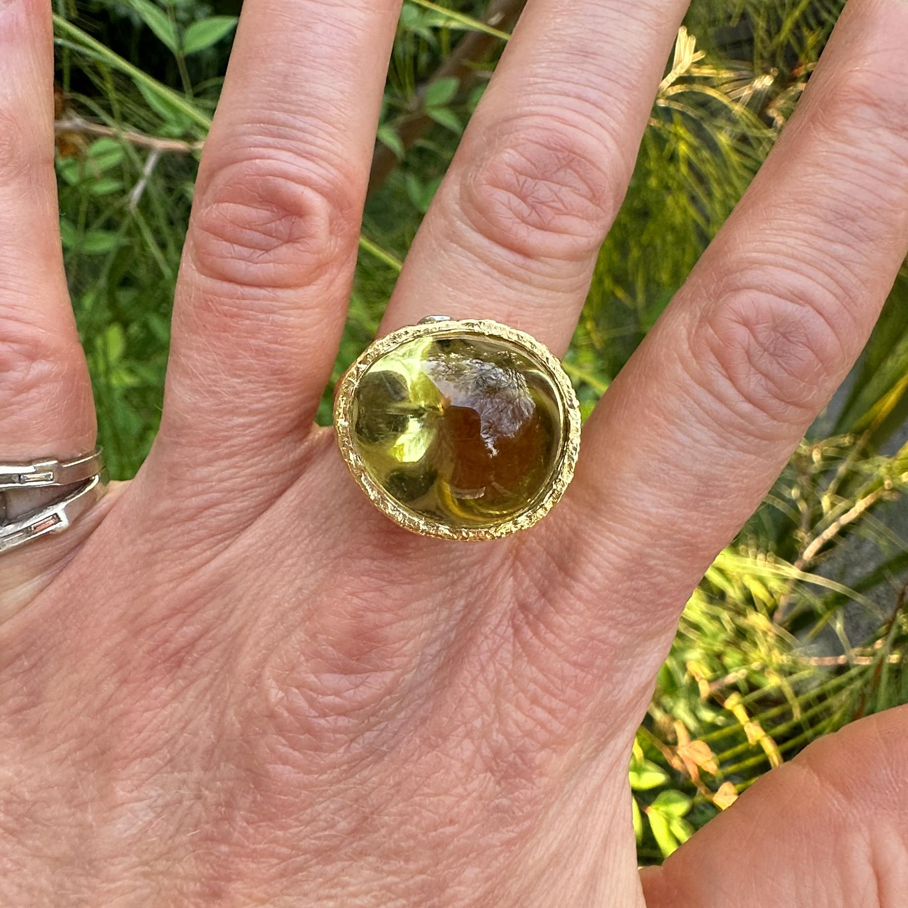 This freeform solitaire was designed and sculpted here in our shop by Eytan Brandes.  It's a one-of-a-kind piece created specifically to show off a huge, roughly egg-shaped lemon citrine cabochon.  The stone is wrapped in a high-elevation 18K yellow