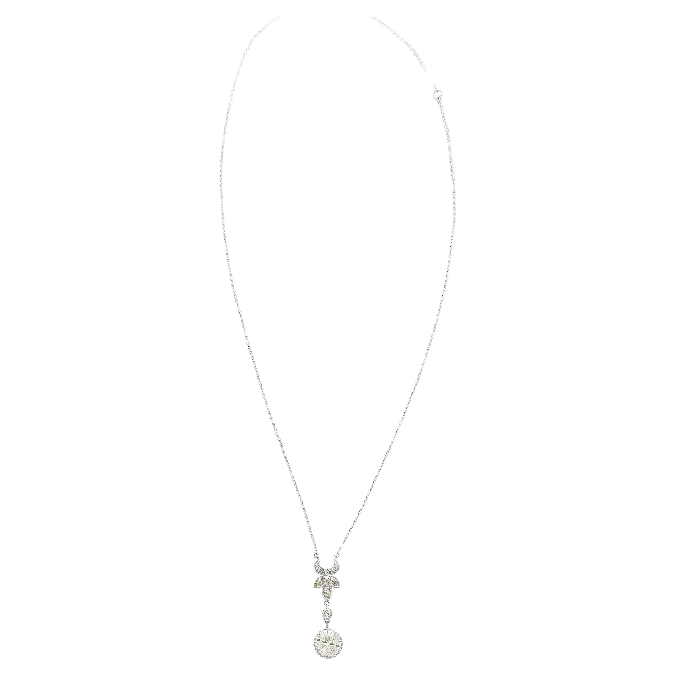 18K white gold vintage pendant necklace. Featuring an antique retro style floral motif drop mounting a 2.6 carat old European cut diamond center stone. The center stone is warm, with excellent clarity and a vintage flair. Adorned with 3 drop cut and