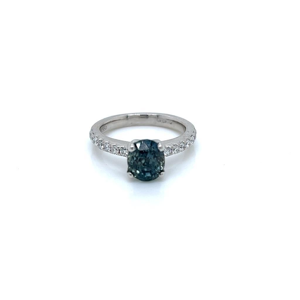 2.6 Carat Oval Teal Sapphire and Diamond Ring in Platinum

This gorgeous ring features an enchanting 2.6 carat oval Teal Sapphire held in a claw setting on a Platinum Ring. Set in the platinum band on either side of the jewel is a row of round