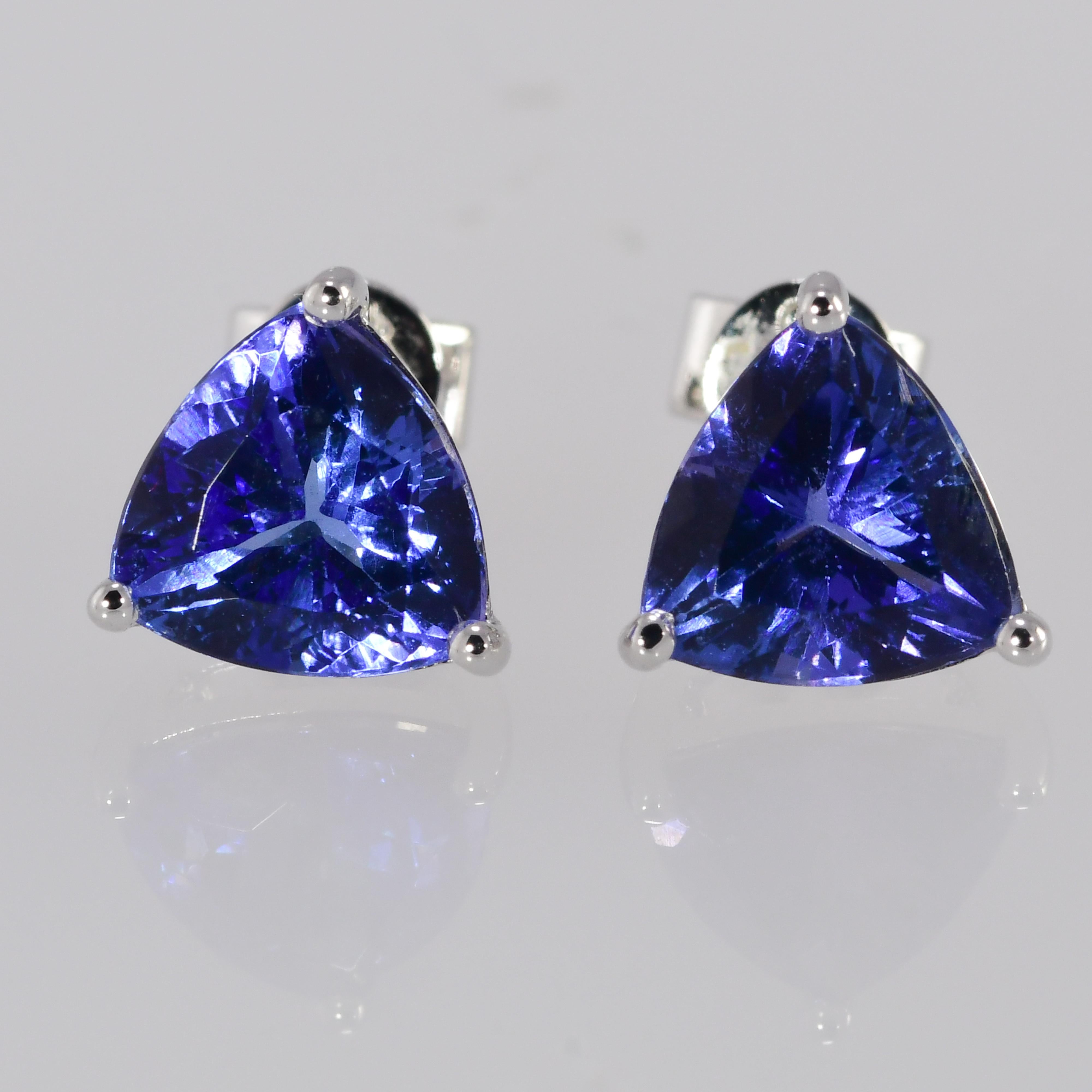 Brilliant deep slightly violetish blue perfectly match triangular brilliant natural tanzanite solitaire earrings. 2.6 carat total gem weight. 
The tanzanite are set in a three prong basket with posts and high quality earring backs. The 14 karat