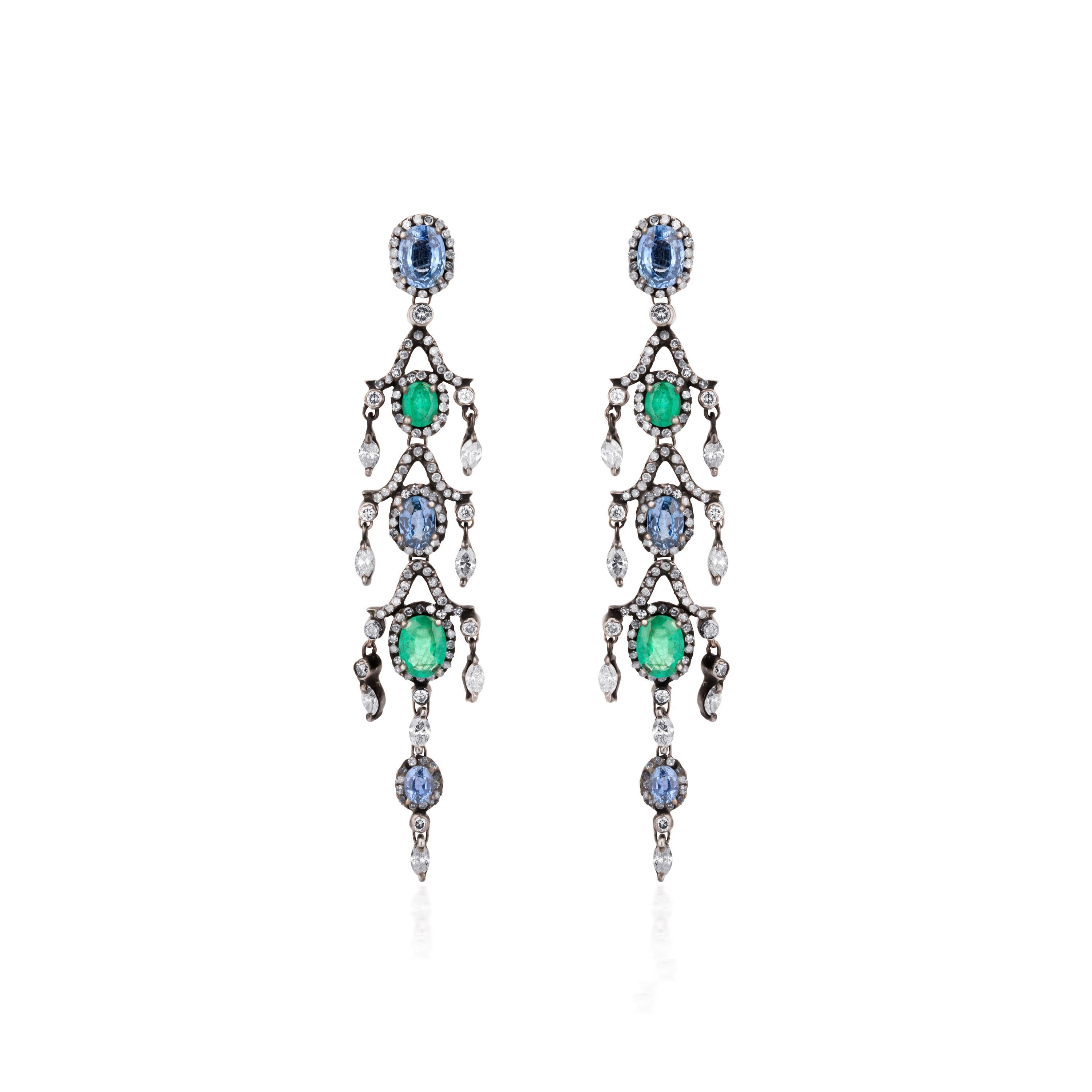 These lovely Victorian chandelier drop earrings, handcrafted in 18K gold and 925 sterling silver swing back and forth with your every move. Each earring features oval faceted emeralds and sapphires alternating with each other, embellished all around