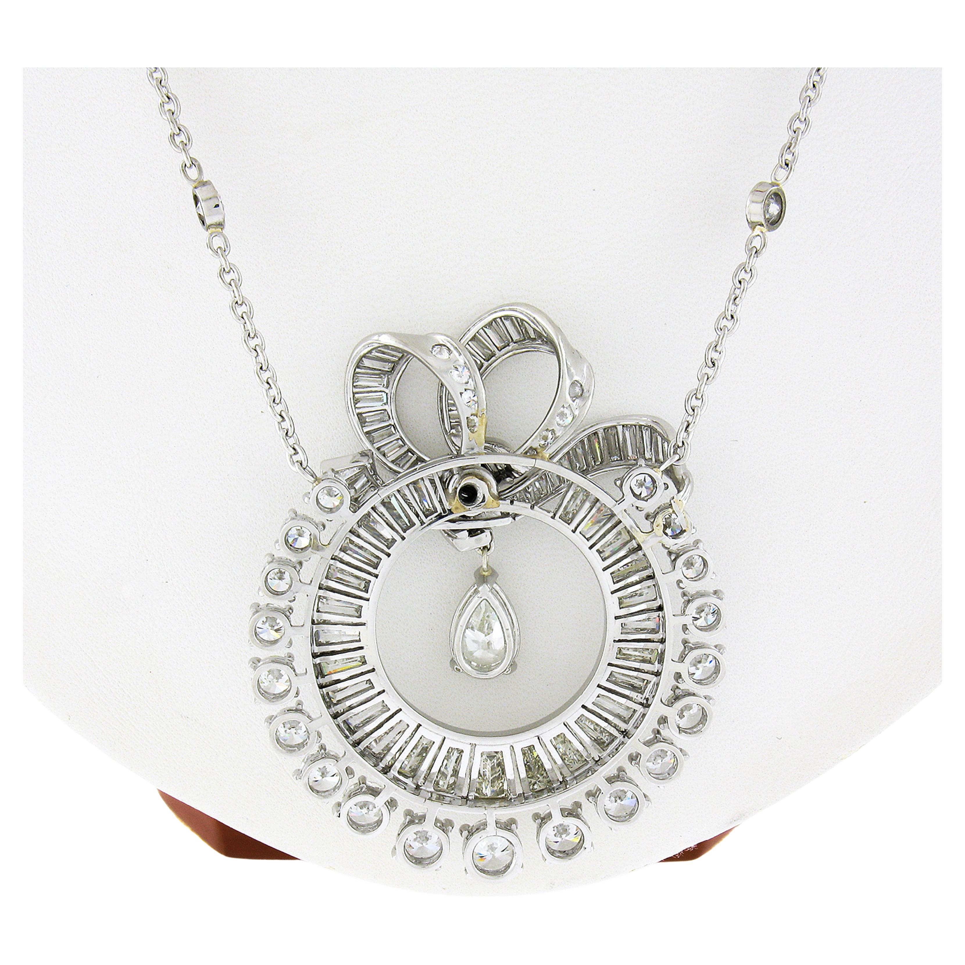 This is a truly jaw dropping vintage statement pendant that was crafted in platinum and is drenched with approximately 19.14 carats of very fine quality diamonds throughout. It features a large dual halo design of tapered baguette and round