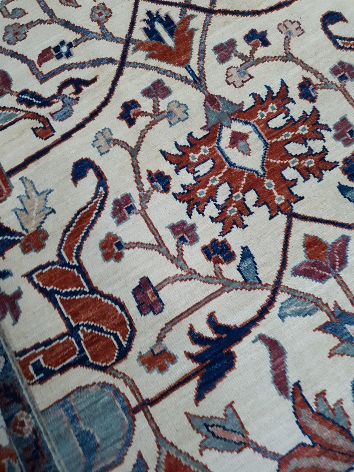 A huge sized rug with design in style of Farahan.
This beautiful rug was hand knotted to fit 21st century interior needs. The background is in beige, the border is a brownish red with floral blue designs.
Farahan design rugs are very looked after