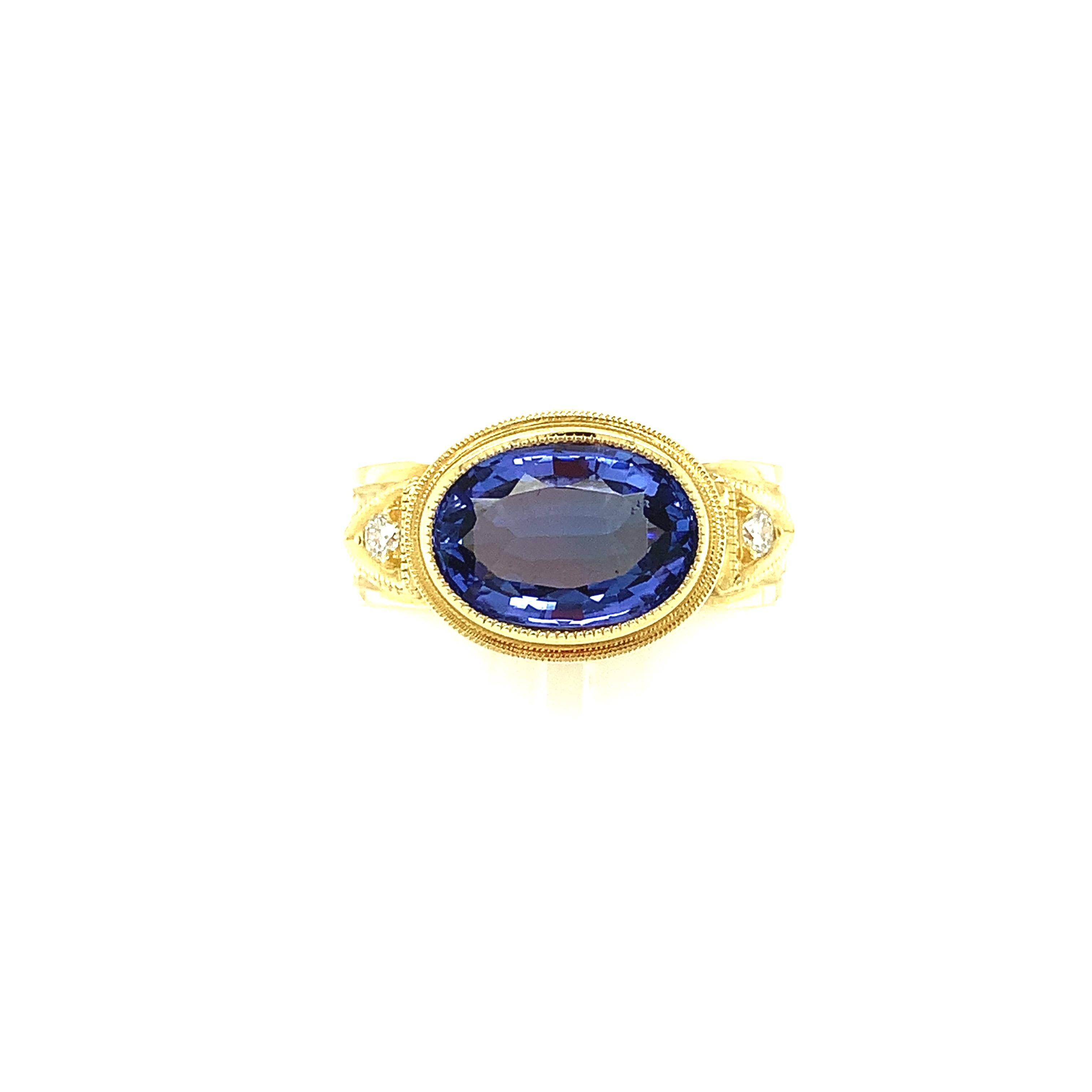 This handmade 18k yellow gold ring features a lovely periwinkle color tanzanite. It has been set 