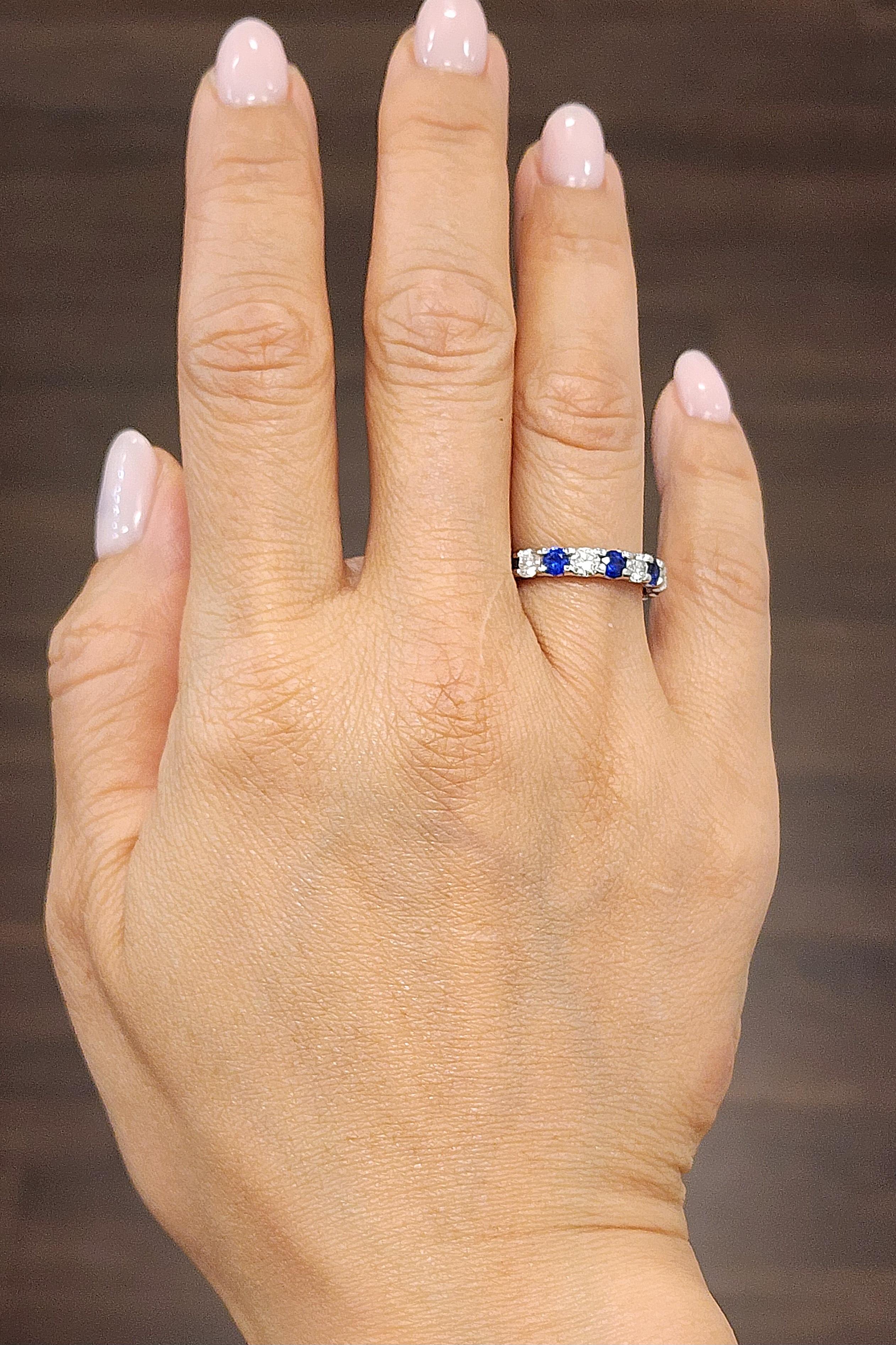 This elegant platinum band ring features a captivating arrangement of 9 round white diamonds and 9 blue sapphires. The diamonds, with a VS2/SI1 clarity and F/G color grade, are set alongside vibrant blue sapphires in a platinum band. The diamonds