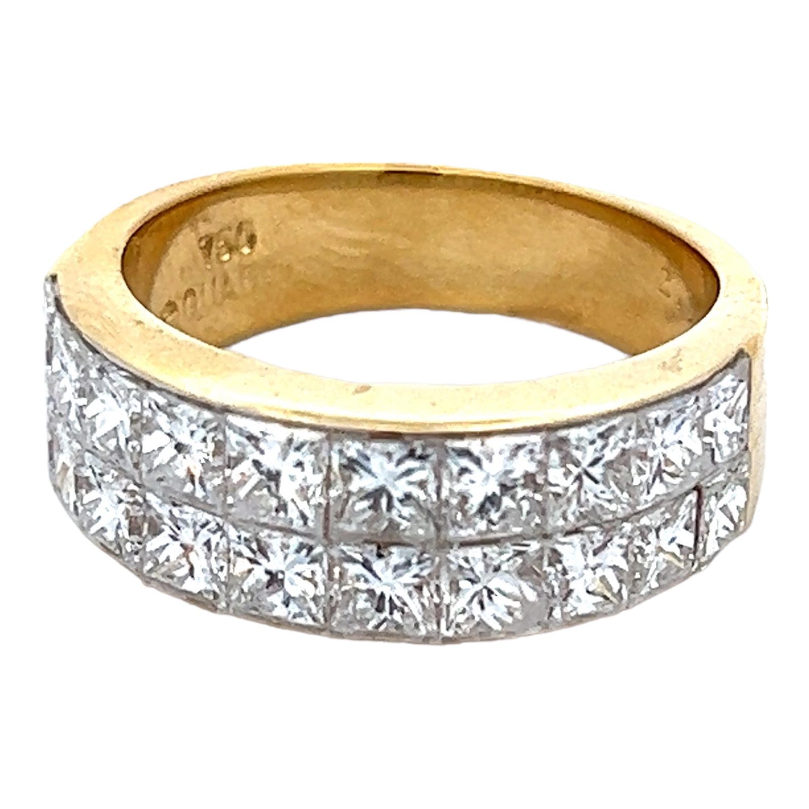 Invisibly set diamond wedding band fashioned in 18 karat yellow gold. The band features 2 rows of 20 princess cut diamonds weighing 2.60 carat total weight. The diamonds are graded G-H color and VS-SI1 clarity. The band measures 7mm in width and is