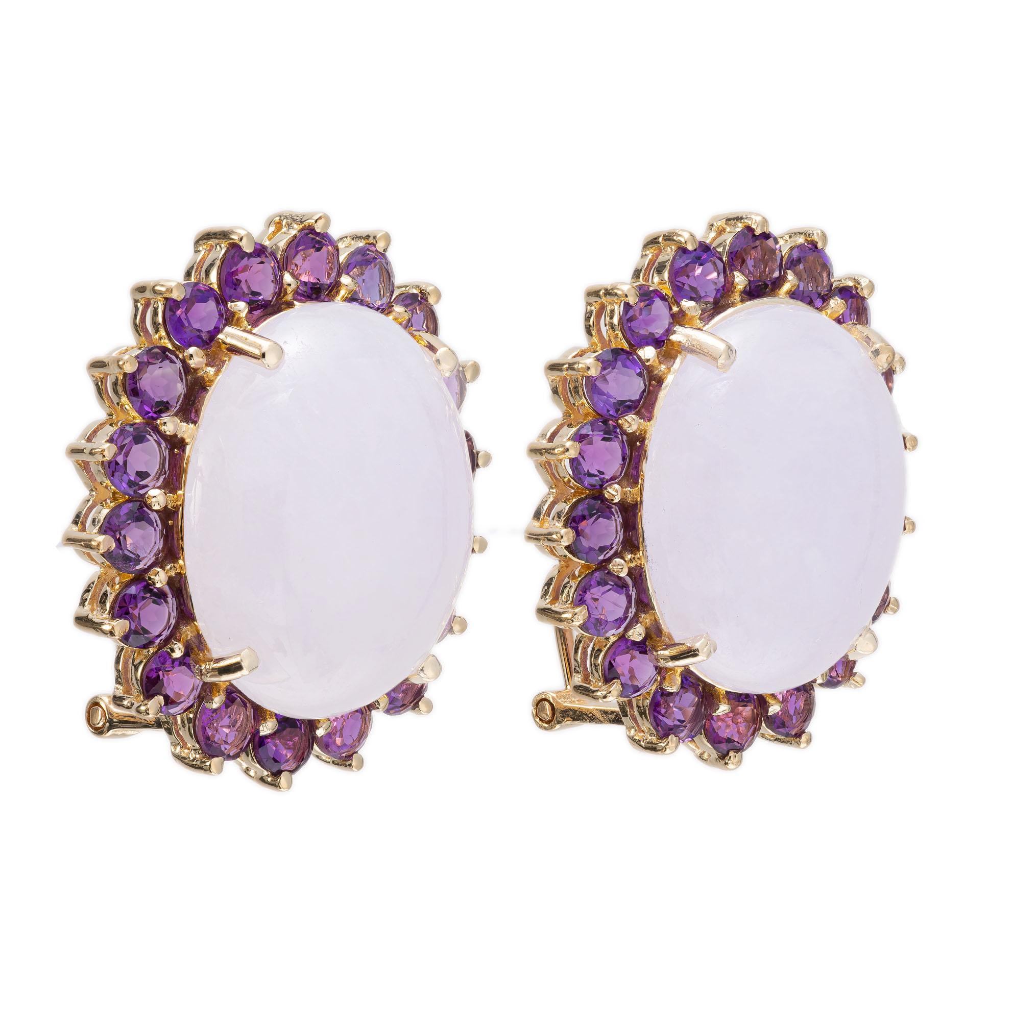 Jade and amethyst earrings. 2 round Light lavender Jadeite Jade stones with a halo of 36 round cut amethysts. 14k yellow gold.

2 oval cabochon lavender jadeite jade, approx. 26.00 carats
36 round purple amethyst, approx. 3.00cts
14k yellow