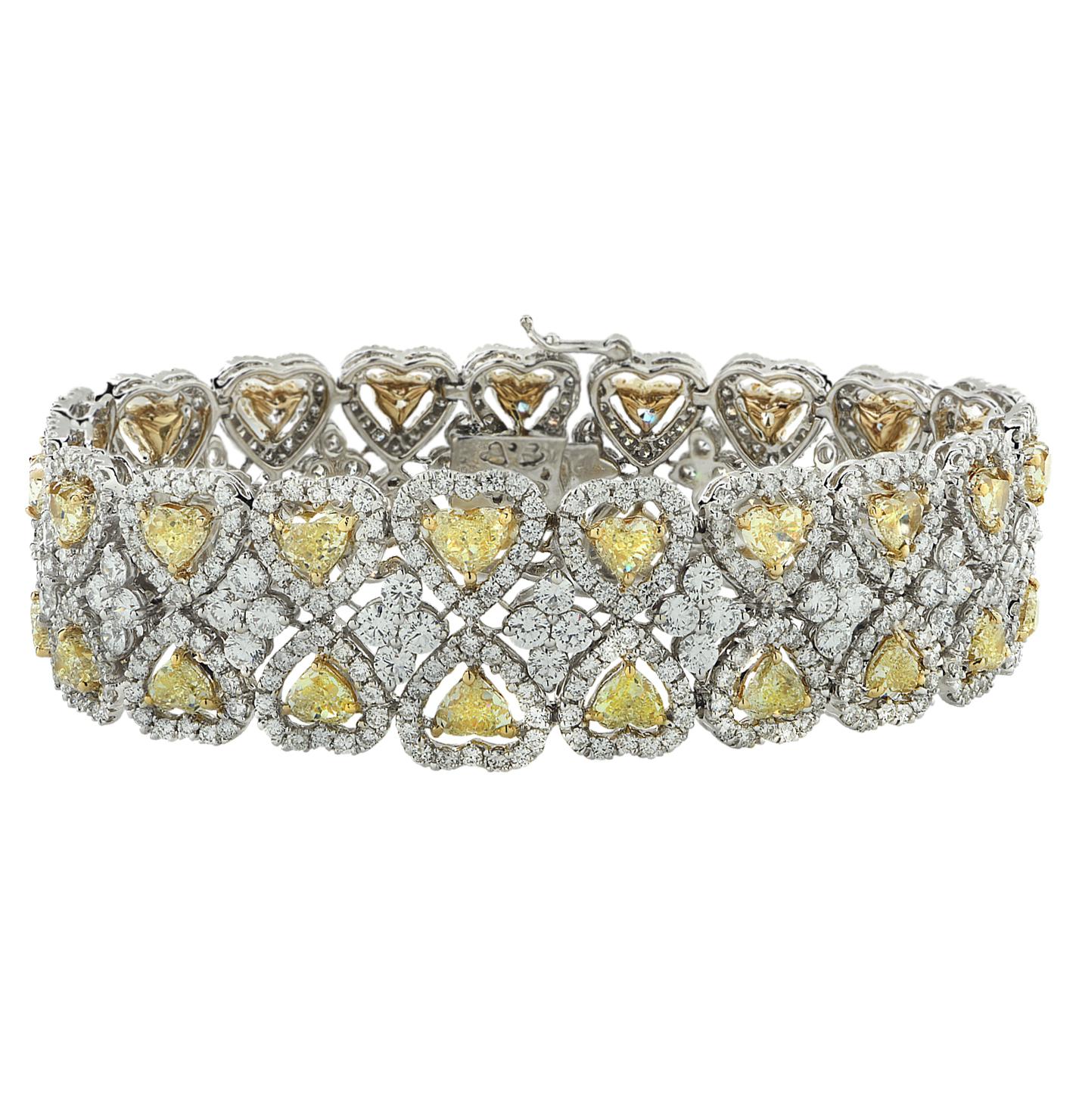 Exquisite diamond bracelet finely crafted in 18 karat white and yellow gold, showcasing 38 fancy yellow heart shape diamonds weighing approximately 13.50 carats total, VS clarity, and 612 round brilliant cut diamonds weighing approximately 12.54