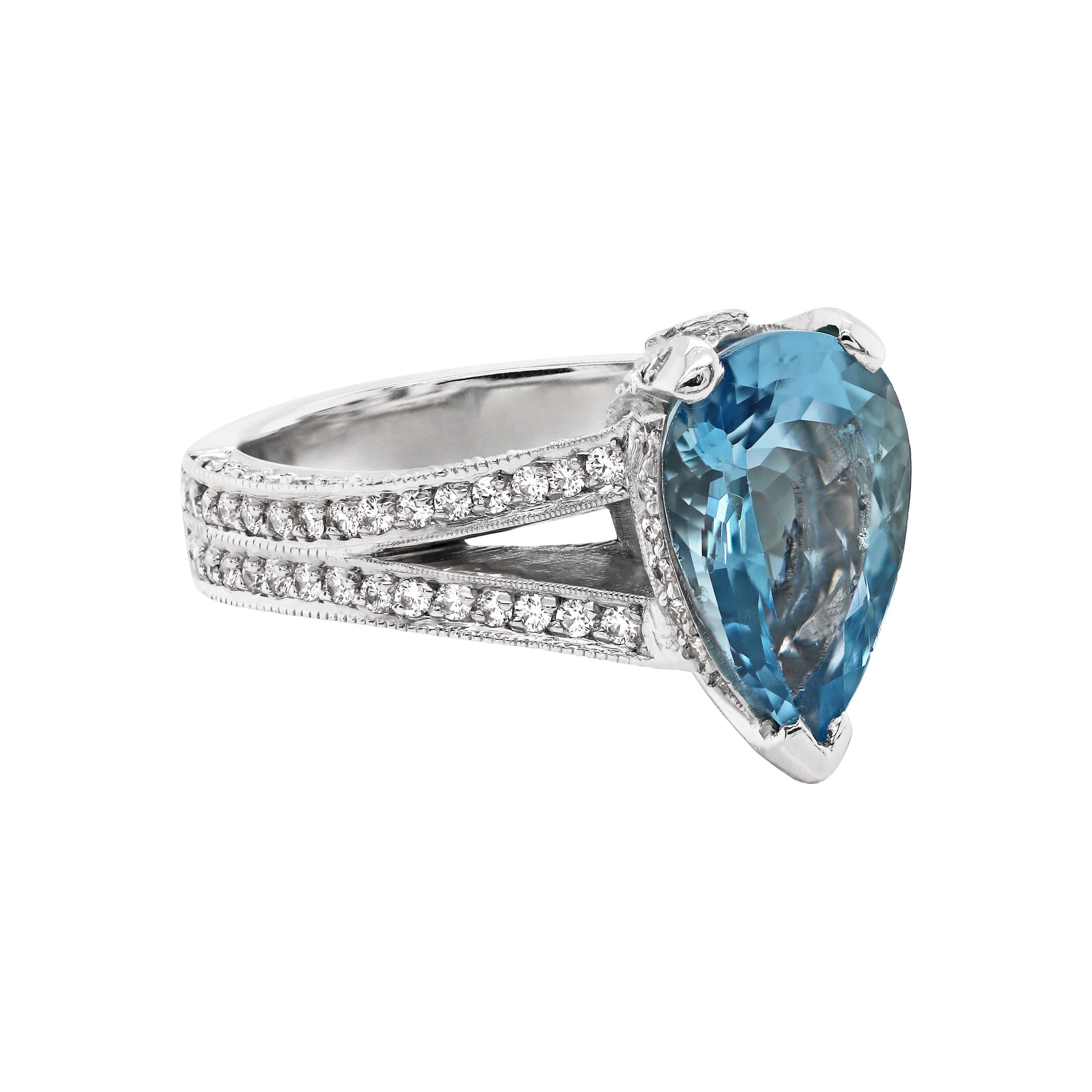 Exquisite platinum engagement ring featuring a beautiful 2.61 carat intense blue pear shaped aquamarine, mounted in a three claw, open back setting. This beautiful piece is elegantly embellished with round brilliant cut diamonds meticulously set on