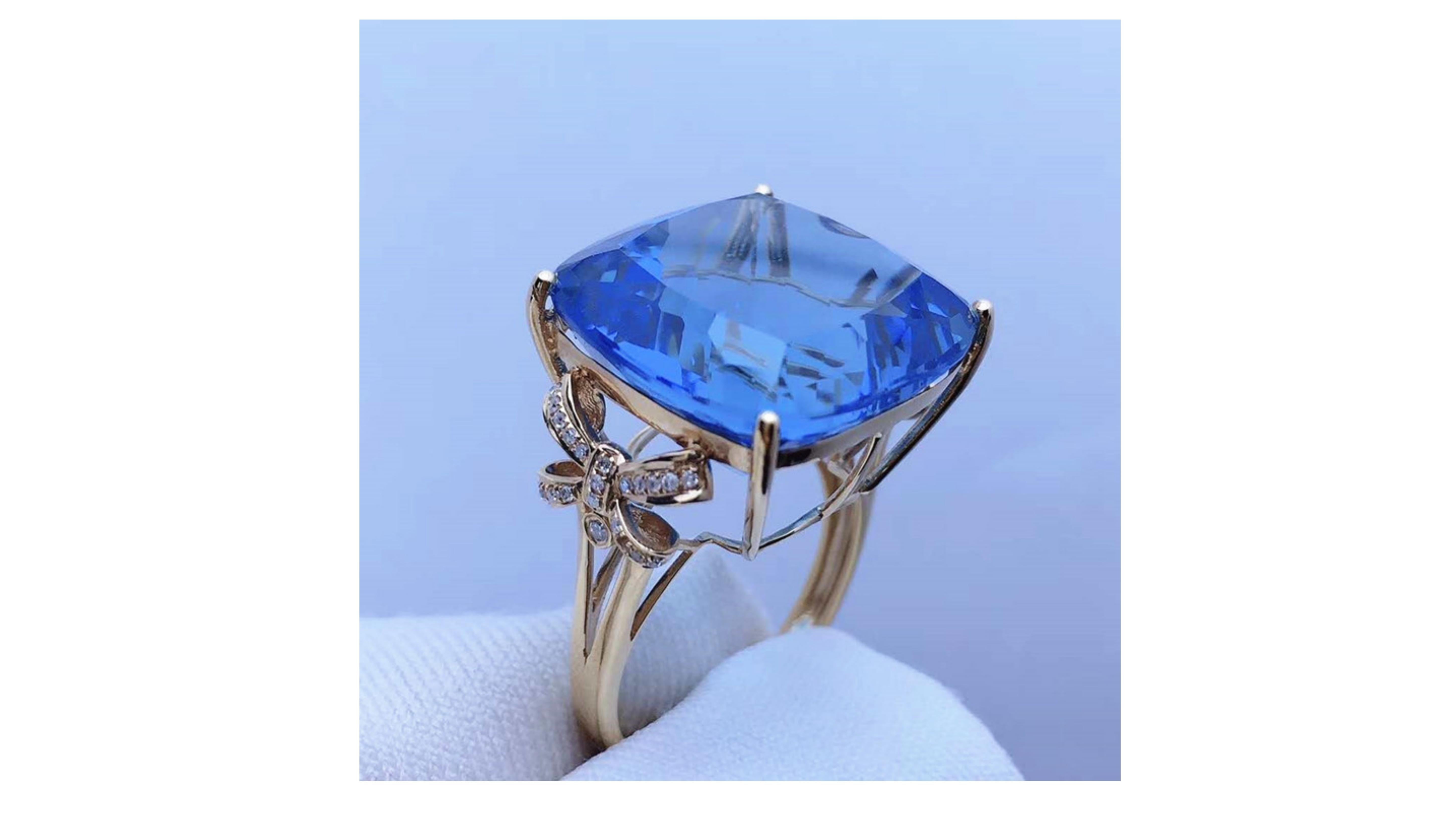 

26.2 Carat Blue Topaz  Cushion cut ring with 44 Diamonds on the sides of band. and set in 18 Karat Rose Gold  . This a wow factor for a blue topaz ring which really does stand out.  If you are looking for anything specific let us know or want it