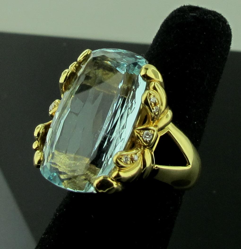 Set in 18 karat yellow gold is a 26.24 carat Aquamarine, surrounded with 10 round brilliant cut diamonds with a total diamond weight of 0.08 carats.  19.50 grams.  Ring size is 7.