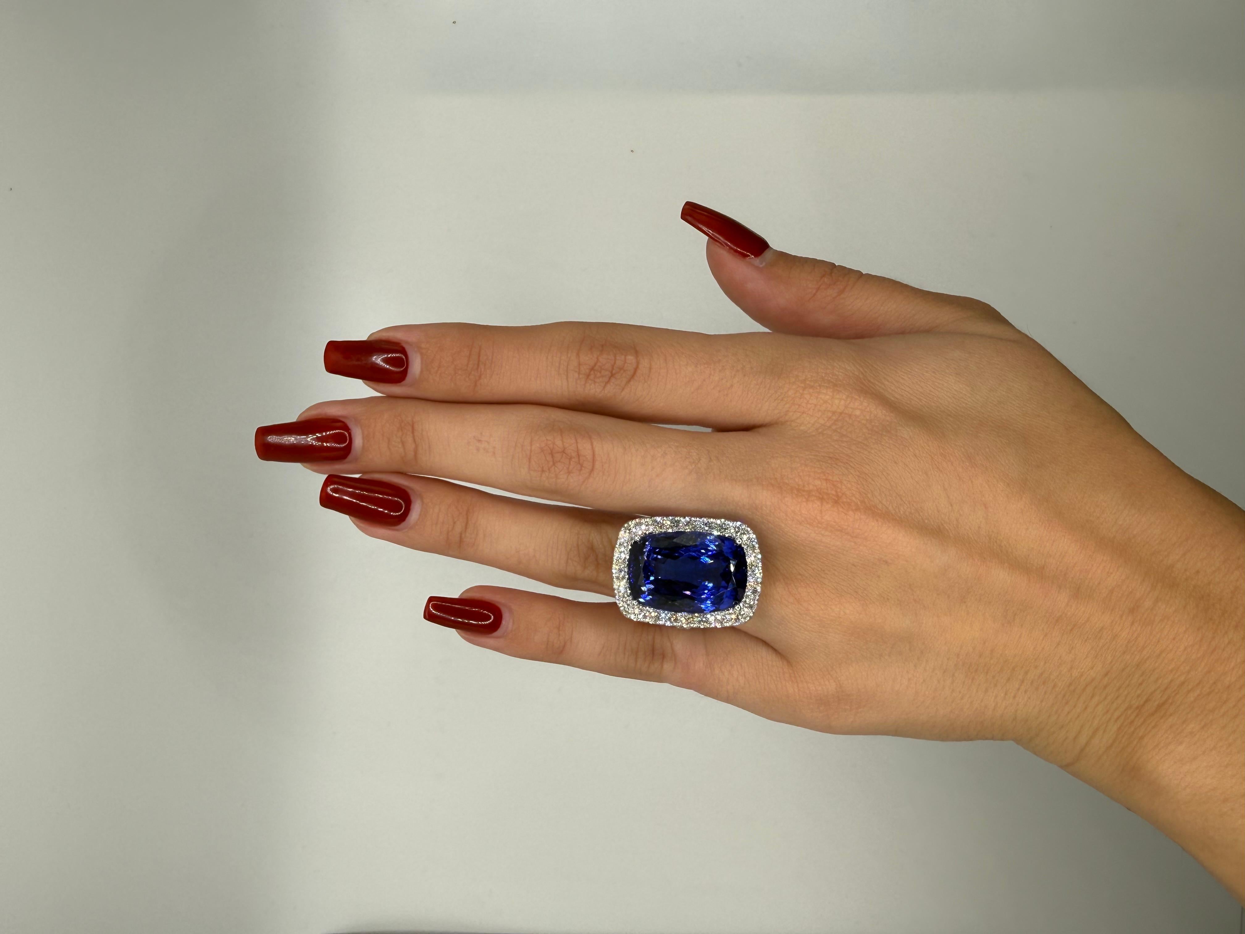 Questo anello da cocktail mozzafiato mette in mostra una straordinaria tanzanite da 26,25 carati con taglio a cuscino, che irradia un blu vivido e vellutato con lampi di viola, una qualità di colore eccezionale che si trova solo nei migliori