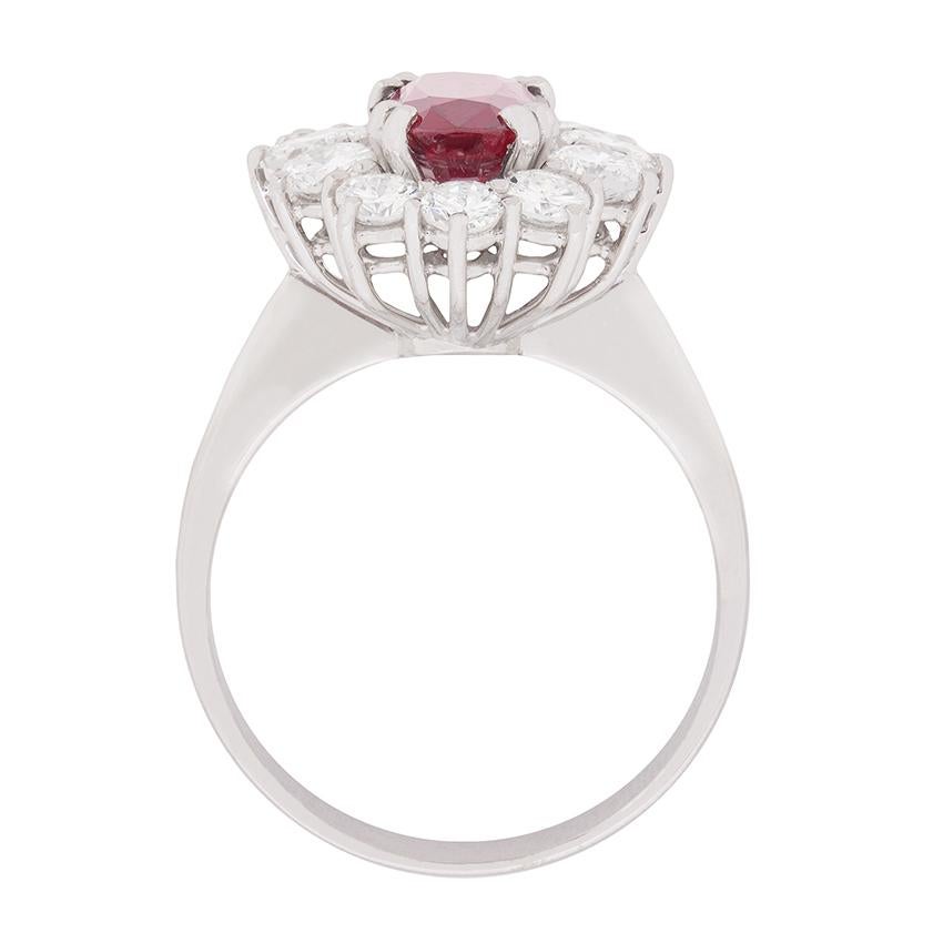 This simply stunning dress ring features a beautifully deep red, 2.63 carat ruby. It is claw set using double pronged claws, and has a perfect oval symmetry. The stone is then supported by a halo of round brilliant diamonds which add a lovely