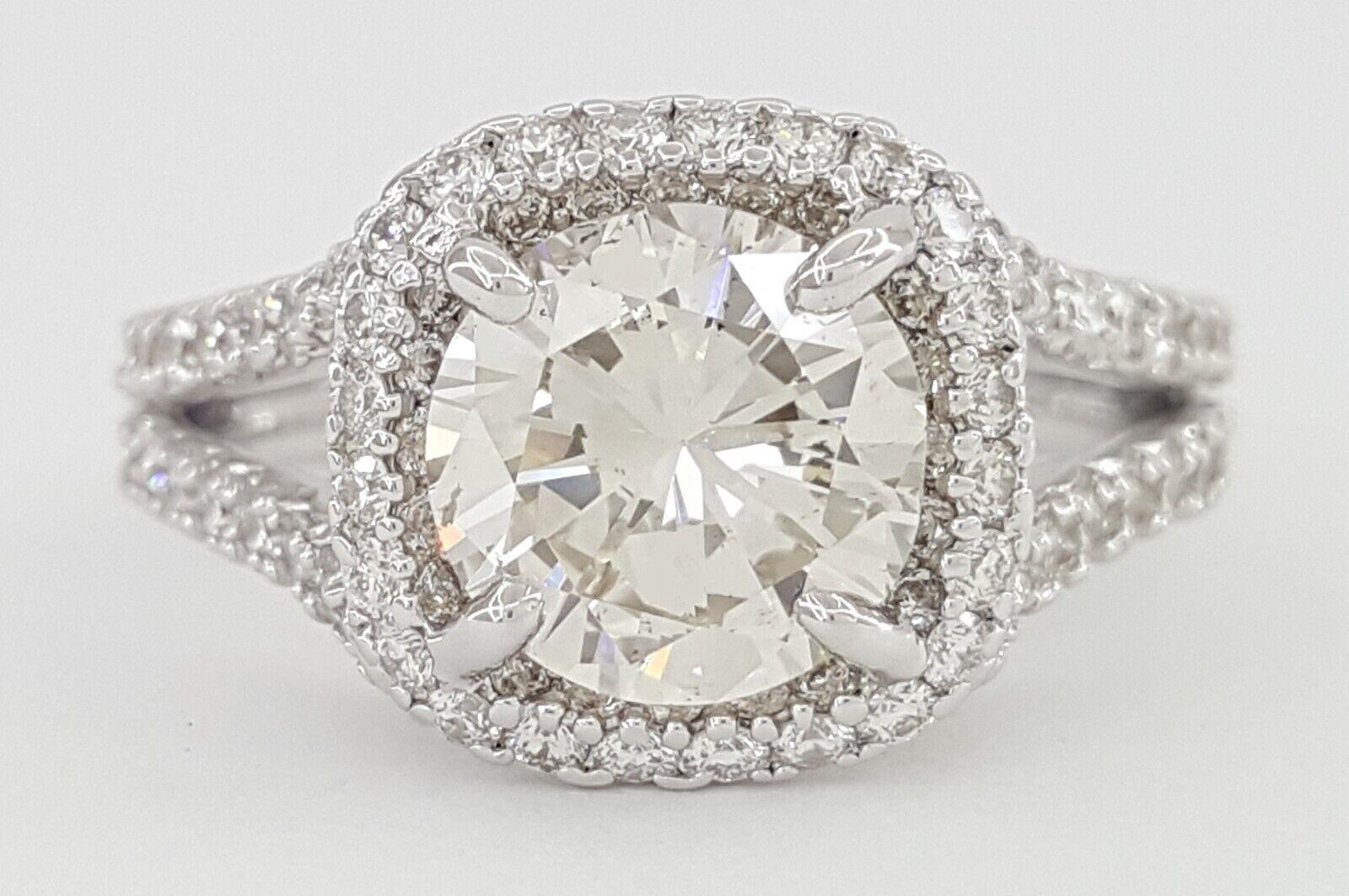 18k White Gold Engagement Ring featuring a Round Brilliant Cut Diamond Halo Split Shank with a total weight of 2.63 carats.

The main stone is a Natural Round Brilliant Cut diamond with a weight of 1.71 carats, exhibiting a K color and SI1-SI2