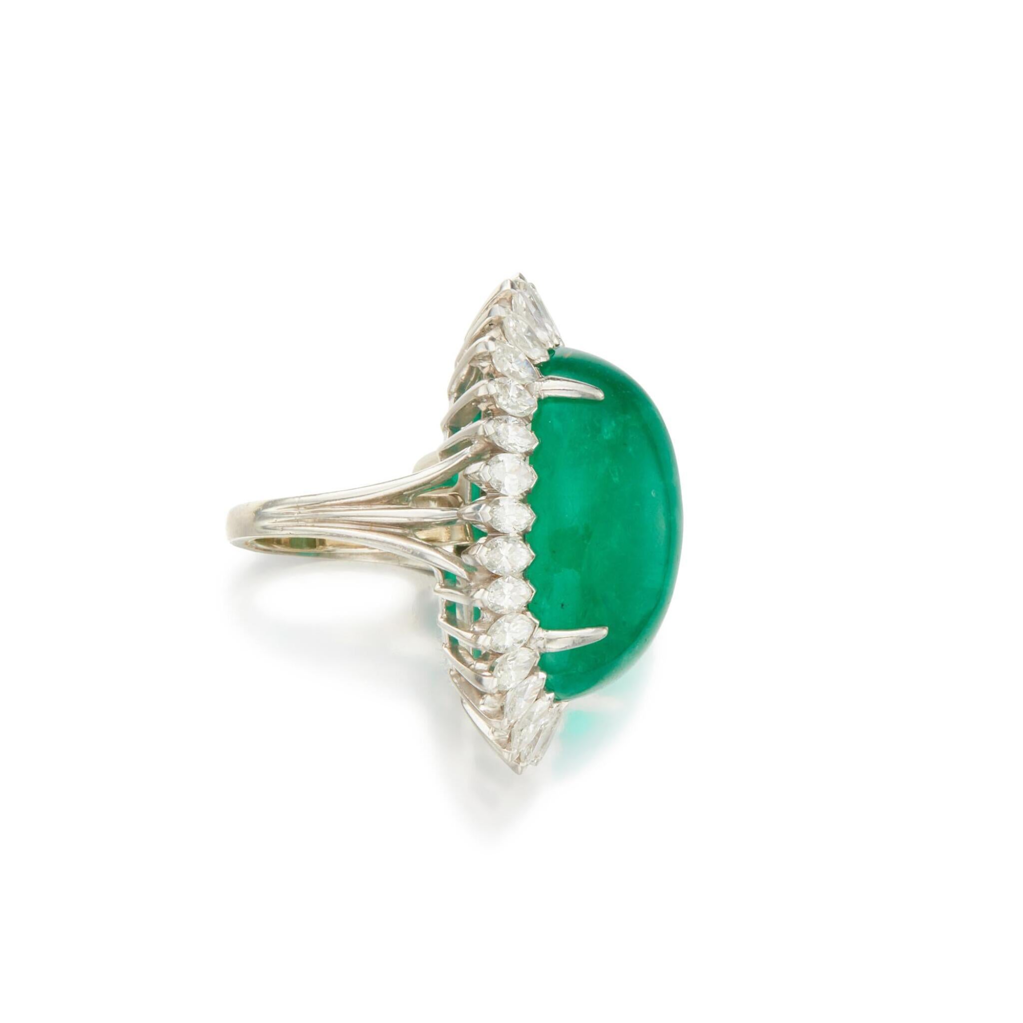 Ein atemberaubender Cabochon-Smaragd mit einer tiefen, leicht bläulich-grünen Farbe, umrahmt von 29 marquiseförmigen Diamanten, ist ein wunderschönes Schmuckstück, das jeden Look aufwertet.

Der Smaragd wiegt ca. 26,30 Karat und hat, wie für