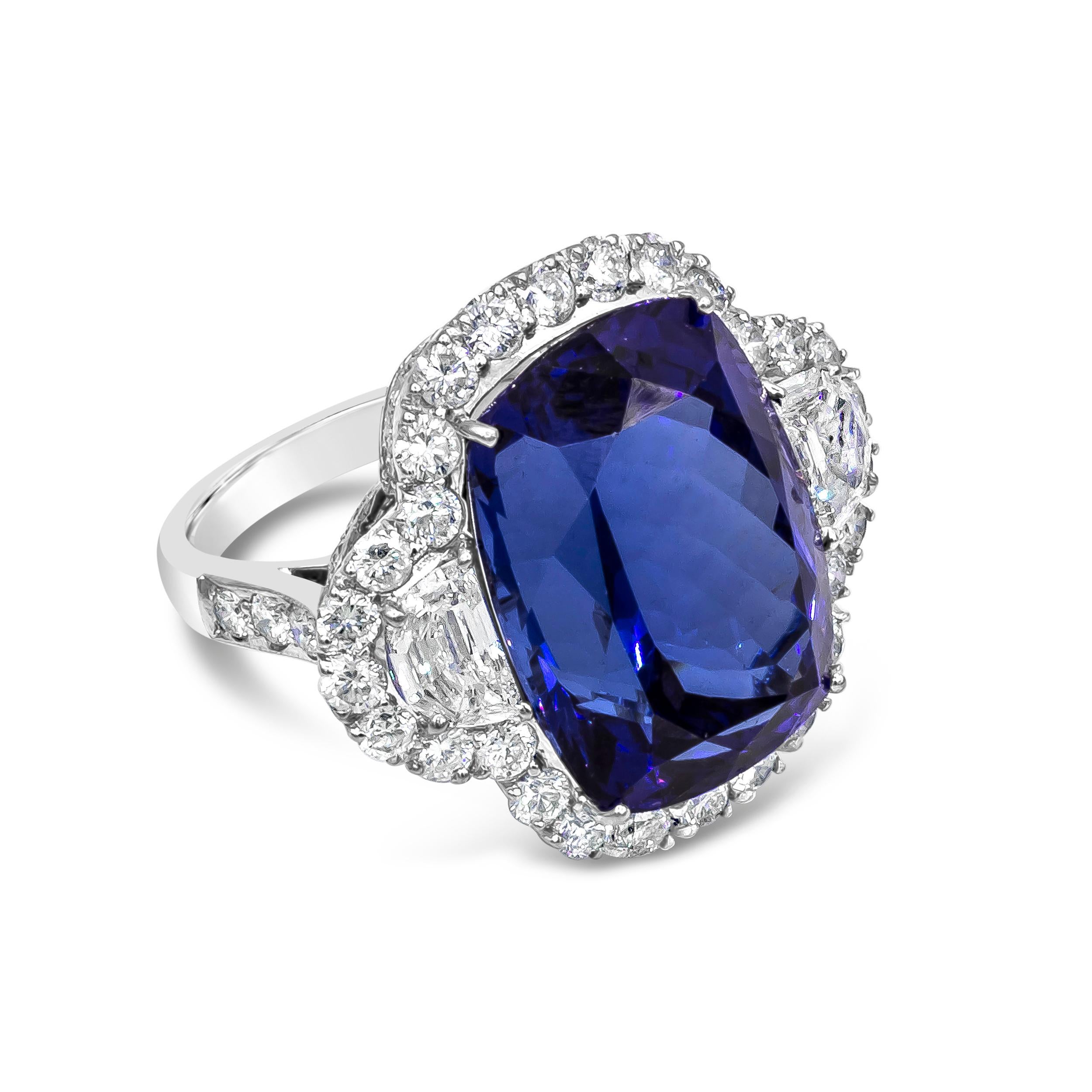 A stunning ring showcasing a rich blue cushion cut tanzanite weighing 26.35 carats. Flanking the center stone are two half-moon diamonds, framed in a brilliant diamond halo. Diamonds weigh 4.52 carats total. Made in 18 karat white gold.


