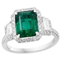 2.64 Carat Emerald Cut Emerald and Diamond Three-Stone Halo Ring in Platinum