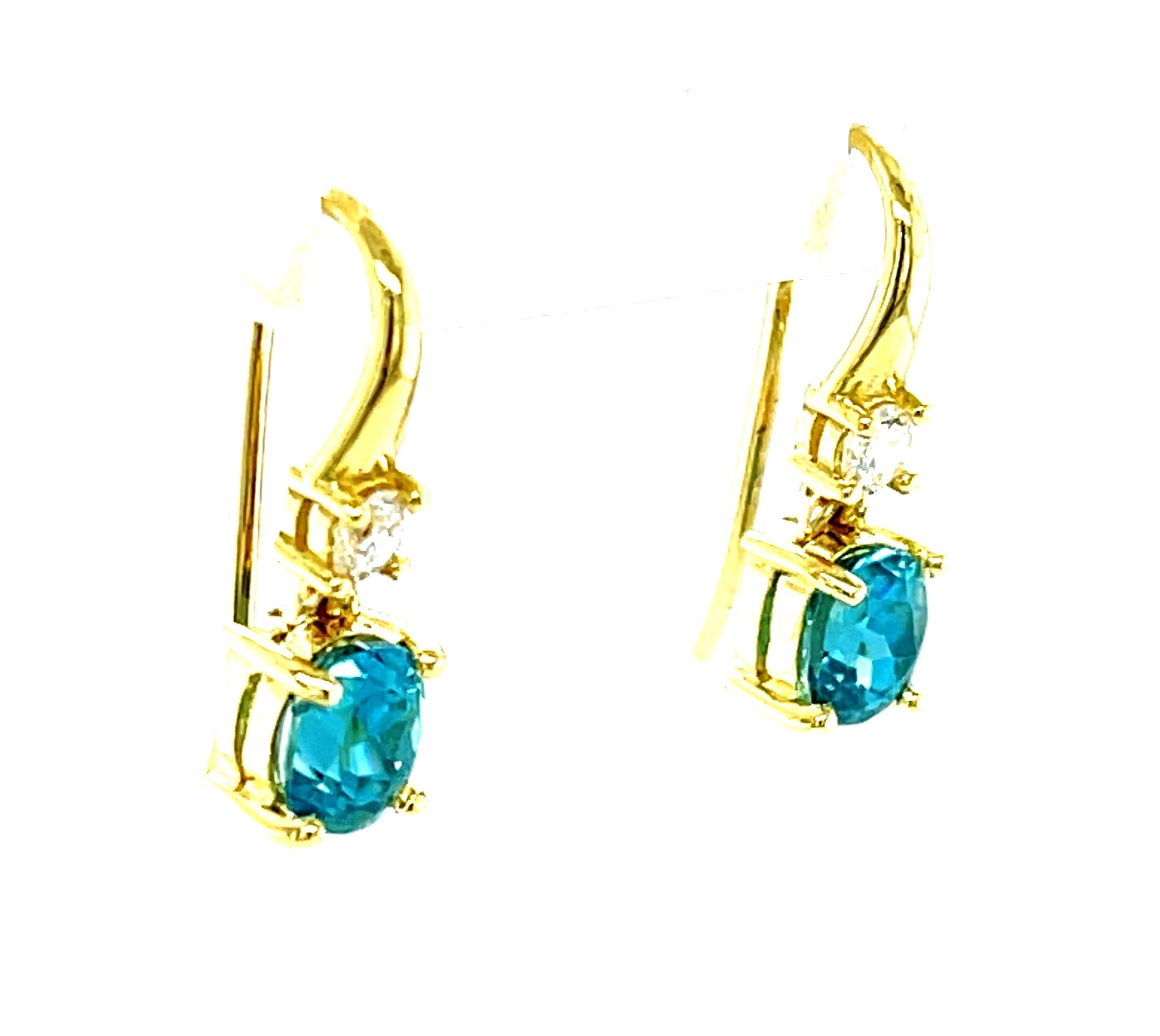 These petite blue zircon earrings are perfect for adding a beautiful pop of vibrant color to any outfit! Two perfectly matched blue zircon ovals are set in 18k yellow gold with diamonds and dangle just below the ear lobe for a look of playful