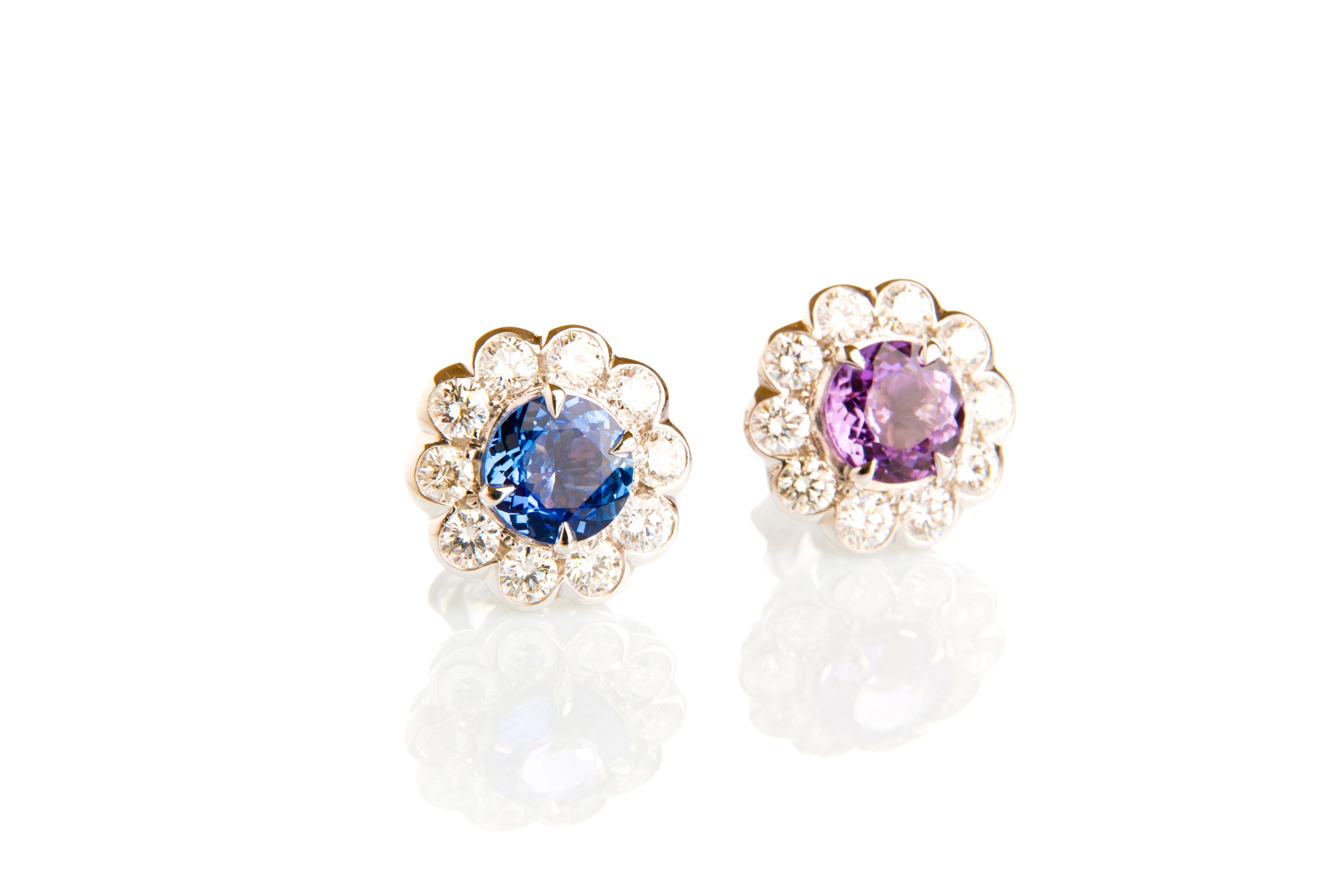 Shaped as flowers, this perfectly symmetrical pair of earrings is hand-finished in 18K white gold and embellished with glistening two sapphires in blue and mauve 2,64 carat as well as twenty round diamonds 1,13 carat are envelopping these two