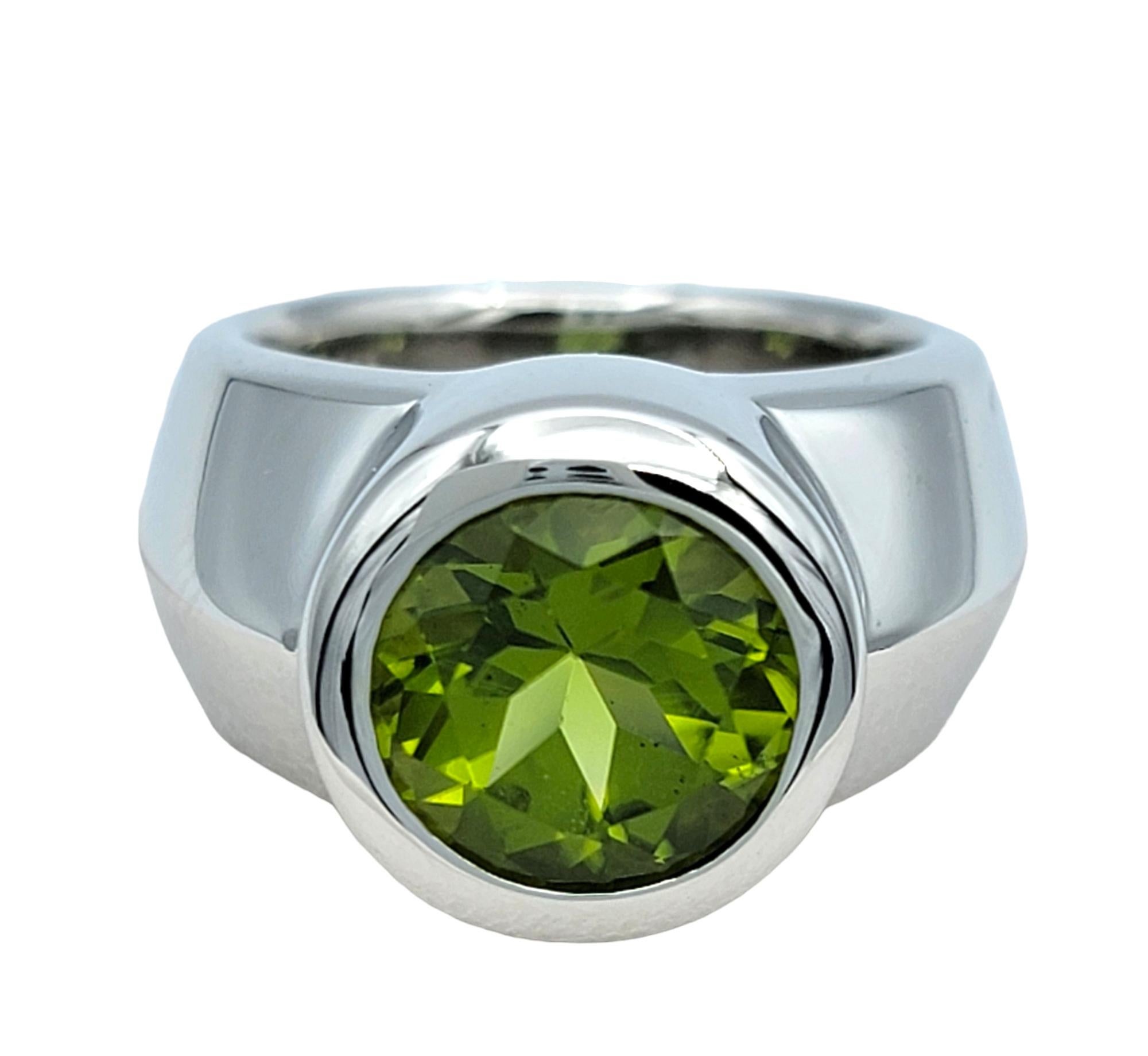 Ring Size: 4.25

Embrace modern elegance with this stunning wide band ring featuring a vibrant round-cut peridot in a sleek bezel setting. Crafted in 14 karat white gold, the wide band design offers a bold yet sophisticated look, perfectly