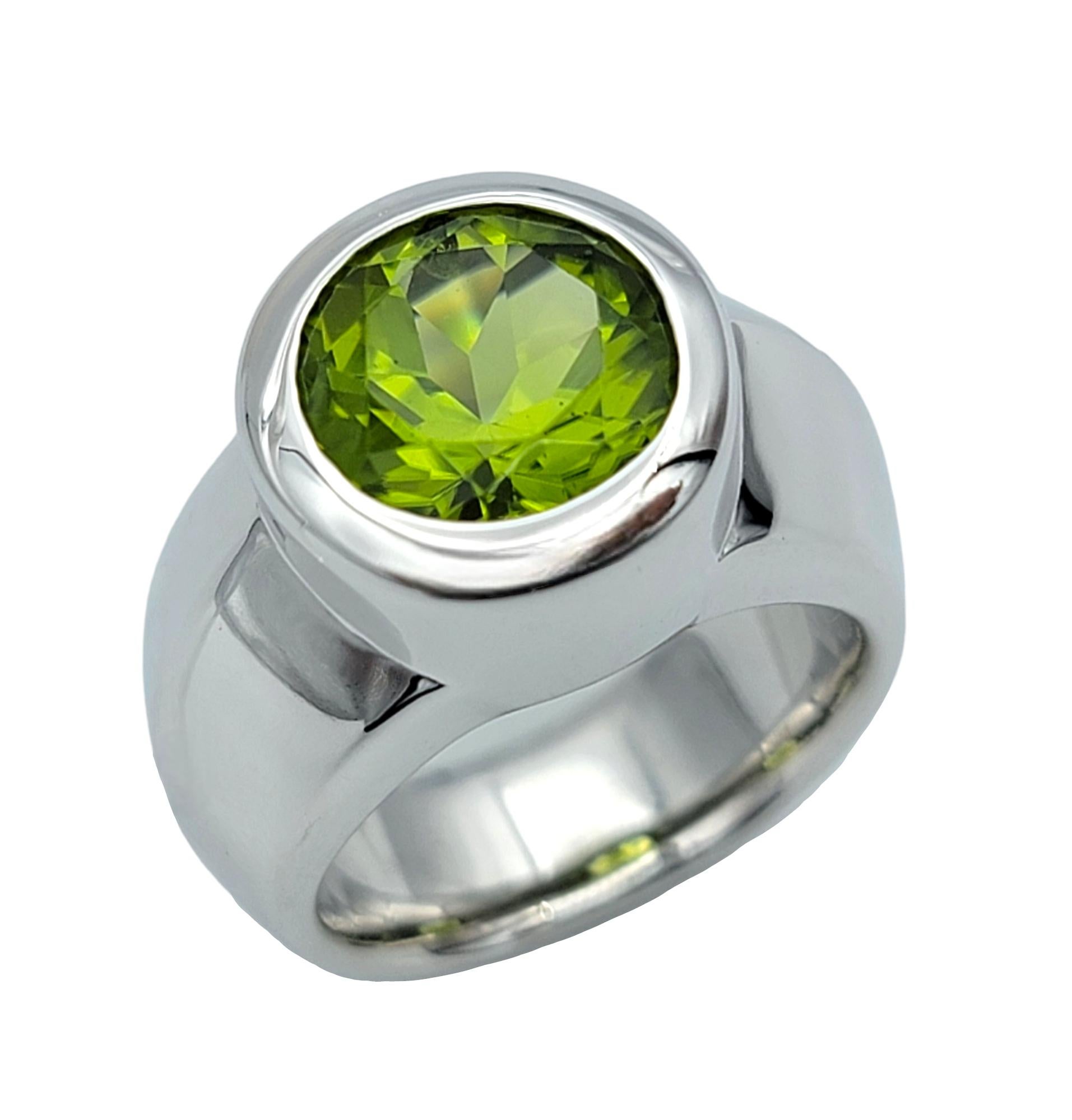 Contemporary 2.65 Carat Round Cut Bezel Set Peridot Wide Band Ring in 14 Karat White Gold For Sale