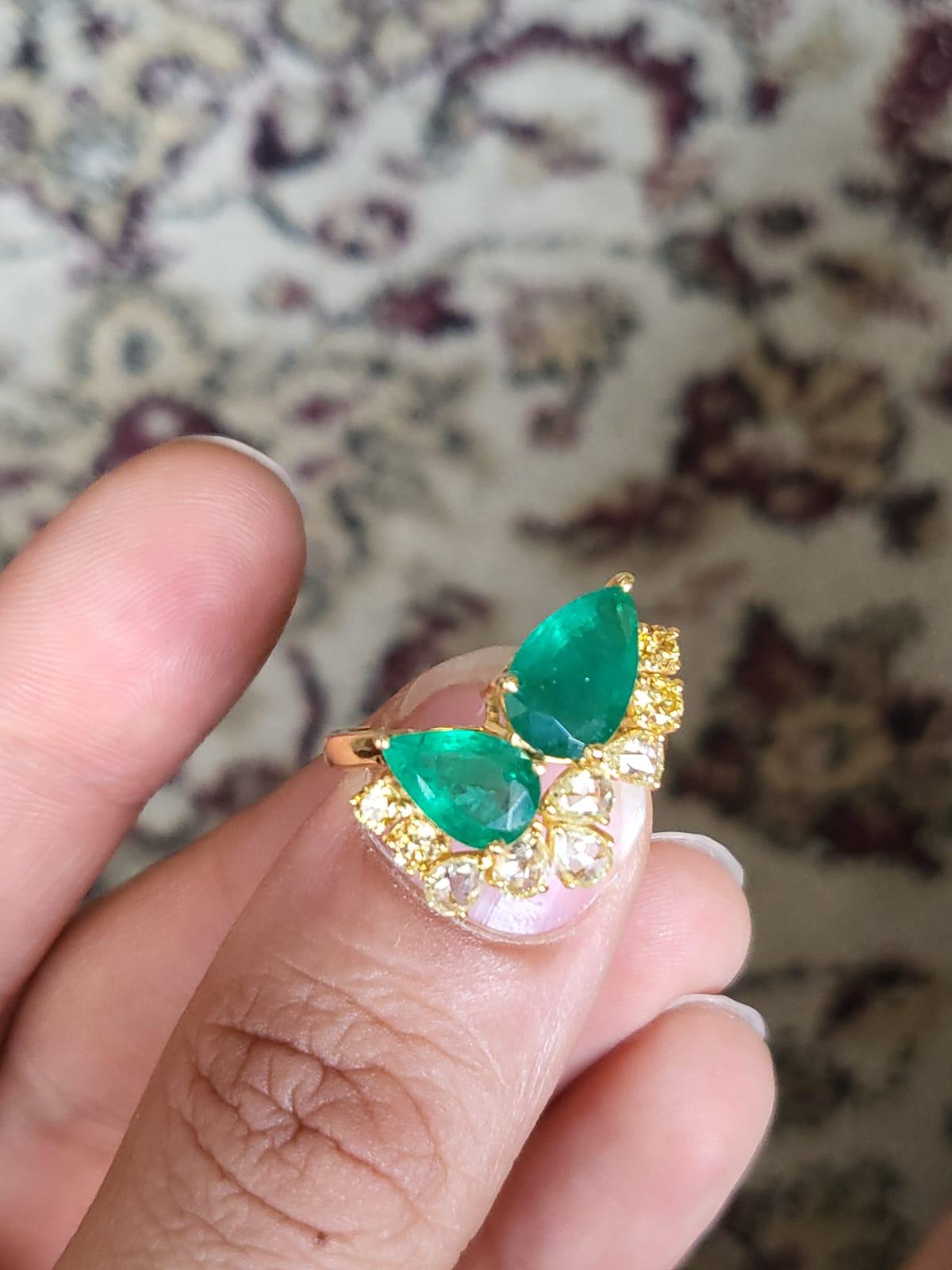 A very gorgeous and one of a kind, Emerald Engagement Ring set in 18K Yellow Gold & Diamonds. The weight of the pear shaped Emeralds is 2.65 carats. The Emeralds are completely natural, without any treatment and is of Zambian origin. The weight of