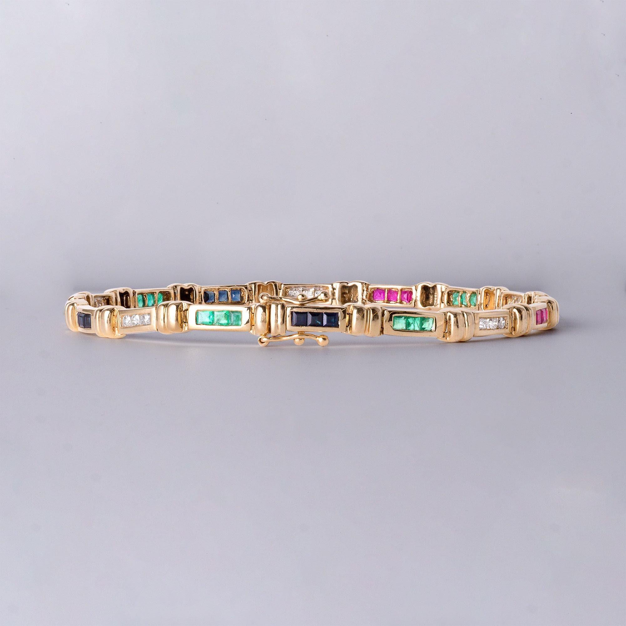 This is an elegant multi-gemstone bracelet, featuring an interchanging channel-set design of princess-cut emeralds, sapphires, rubies, and round brilliant diamonds. Crafted in warm 14K yellow gold.

Features:
12 Princess-Cut Emeralds – 0.70