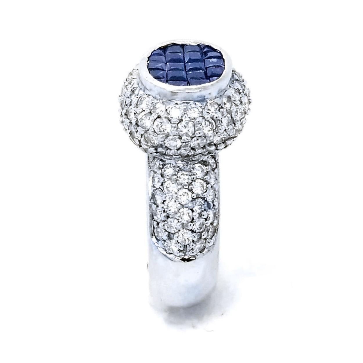 18K Gold Pave Set Diamond Ring with Oval Shaped Center comprised of  20 Invisible Set Princess Cut Blue Sapphires (Total Gem Weight 1.15 Ct) surrounded by 3 Rows of Pave Set Halo of diamonds and 5 Rows of Pave Set diamond on the shank with total