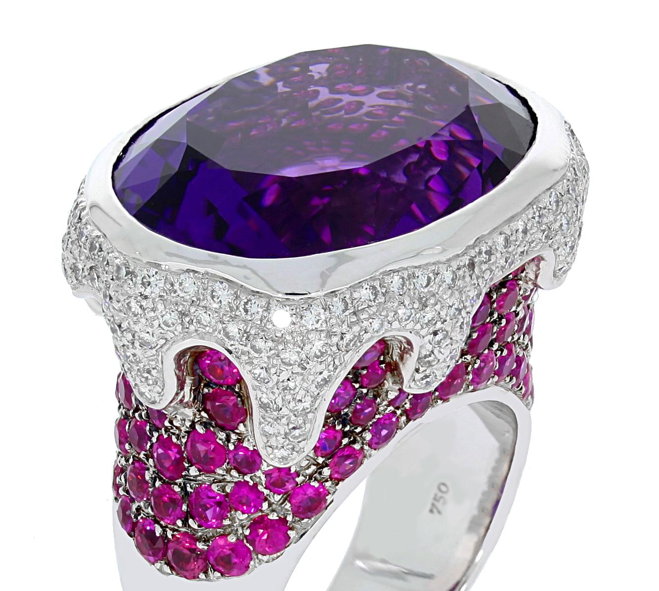 This sensational 18 carat white gold ring by Chatila features a luxurious 26.58 carat rich purple amethyst gemstone, accentuated by 175 white diamonds with a total weight of 1.04 carats, as well as 26.58 carats of 105 pave-set pink rubies.