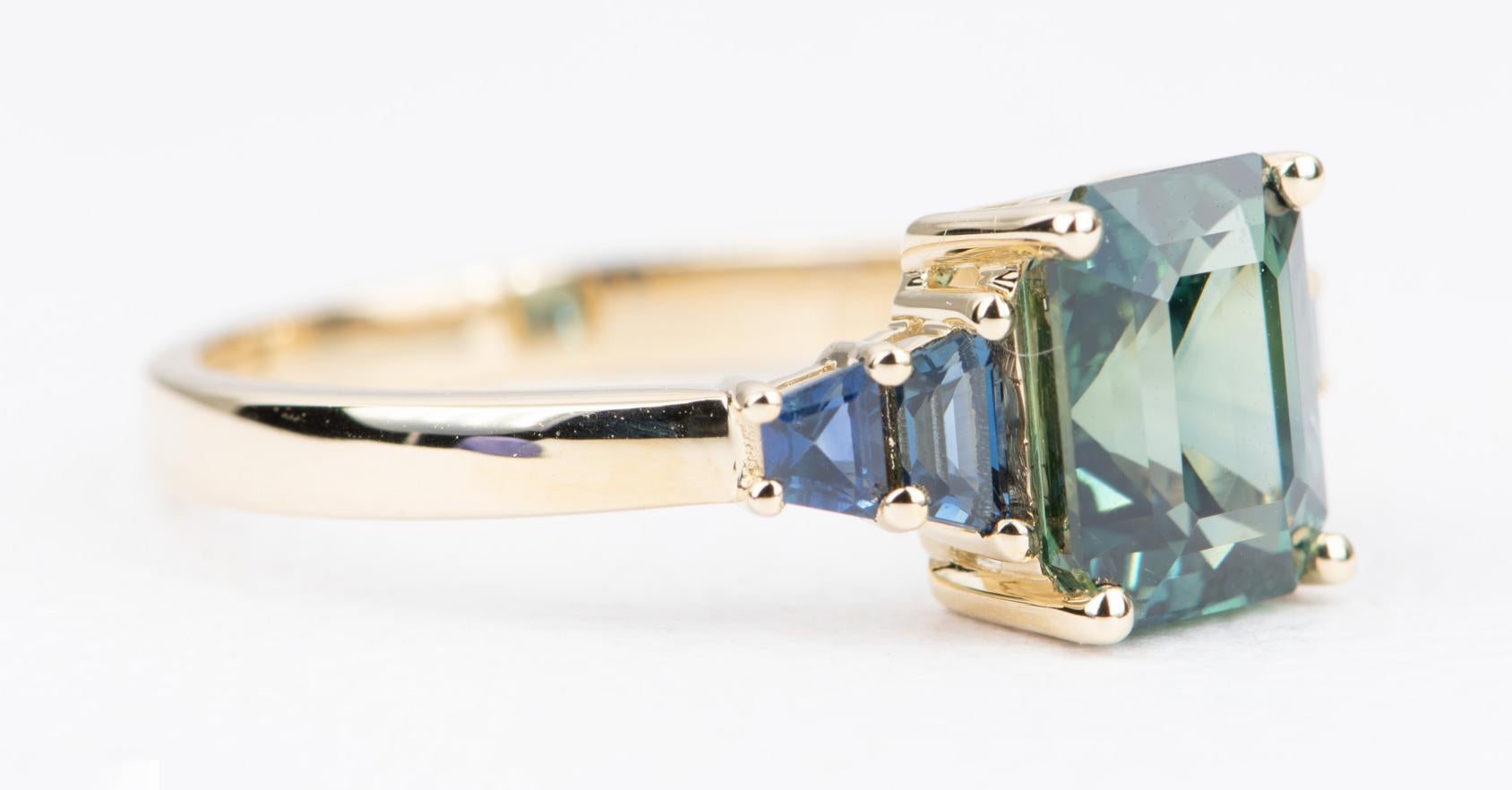 ♥ Dies ist ein atemberaubender Ring mit einem wunderschönen blaugrünen Saphir in der Mitte:: flankiert von blauen Saphiren in Fancy-Form an der Seite. 
♥ Der Mittelstein hat die erstaunlichste Mischung aus blauer und grüner Farbe! Sehr satte Farbe