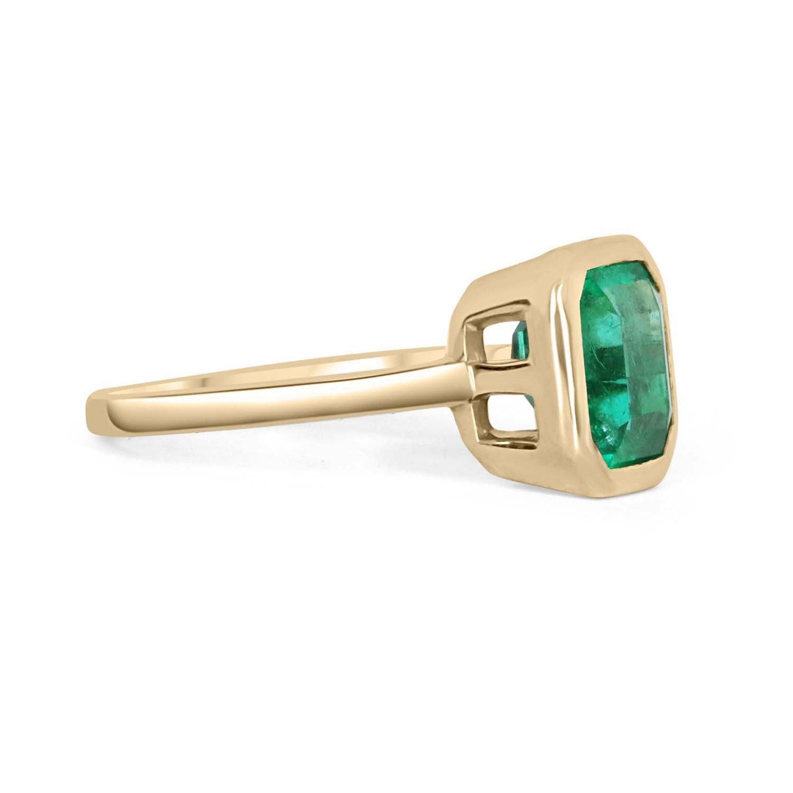 Displayed is a bluish-green Colombian emerald, solitaire, emerald-cut bezel ring in 18K yellow gold. This gorgeous solitaire ring carries a full 2.65-carat emerald in a sleek bezel setting. The emerald has incredible clarity and luster. This emerald