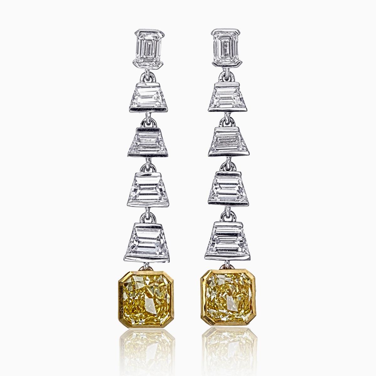 A brand new dangle earrings featured by Rewa Jewels designed in 18 karat white gold. 

The masterpiece is uniquely designed with two cushion cut yellow diamonds weighing approximately 2.66 carat. There are two emerald cut diamonds weighing 0.49