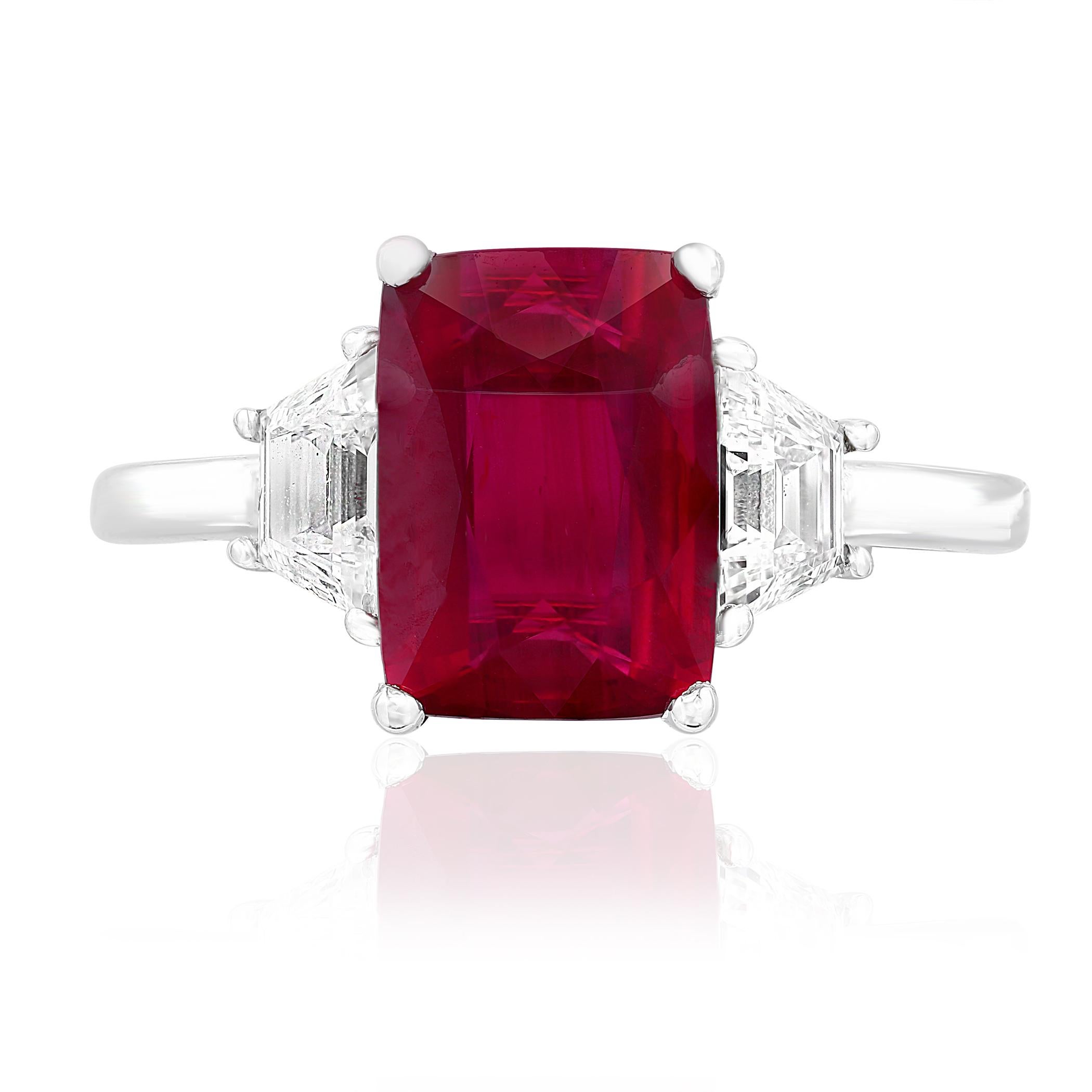 Showcases an Emerald cut, Natural Ruby weighing 2.66 carats, flanked by two brilliant cut trapezoid diamonds weighing 0.61 carats total. Elegantly set in a polished platinum composition.