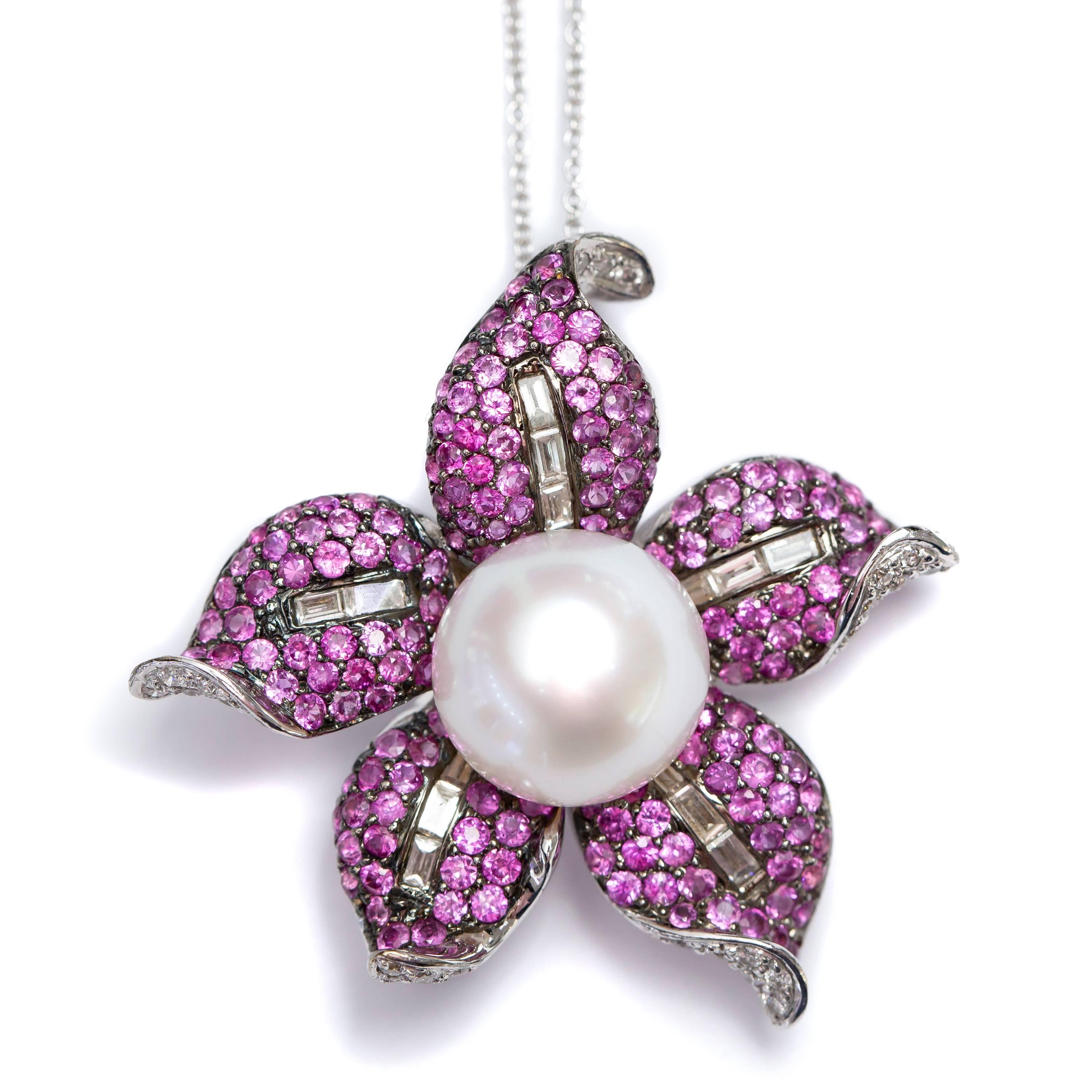 This Gorgeous 2.66 Carat Pink Sapphire Flower Shape Brooch Pendant features 0.57 Carat Color H Clarity SI1 Round and Baguette White Diamonds and a single Fresh water pearl in the center. Chain included, British Hallmarked. 