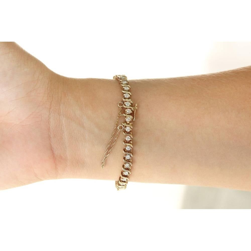 Whiting présente une rangée continue de diamants blancs dans un bracelet classique en or jaune. Des diamants de taille brillante s'alternent harmonieusement avec d'élégants maillons en S dans un sertissage en or jaune 14K. 2,66 carats de diamants