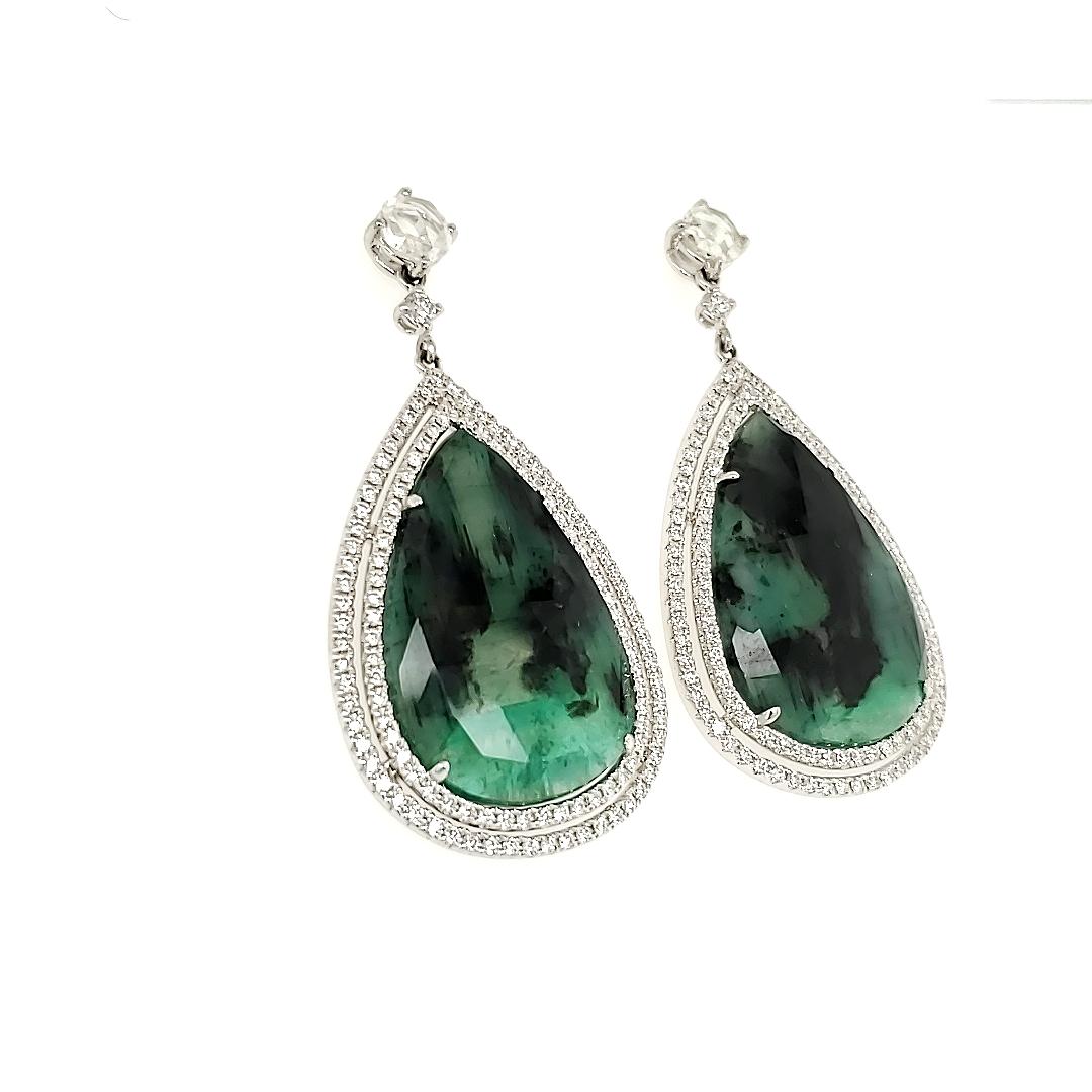 26.76 Carat Pear Shape Emerald And Diamond White Gold Dangle Earrings:

An absolutely beautiful piece, it consists of a pair of Pear Shaped Natural Emeralds weighing a total of 26.76 carat, accented by a two-line halo of White Diamonds weighing 1.56