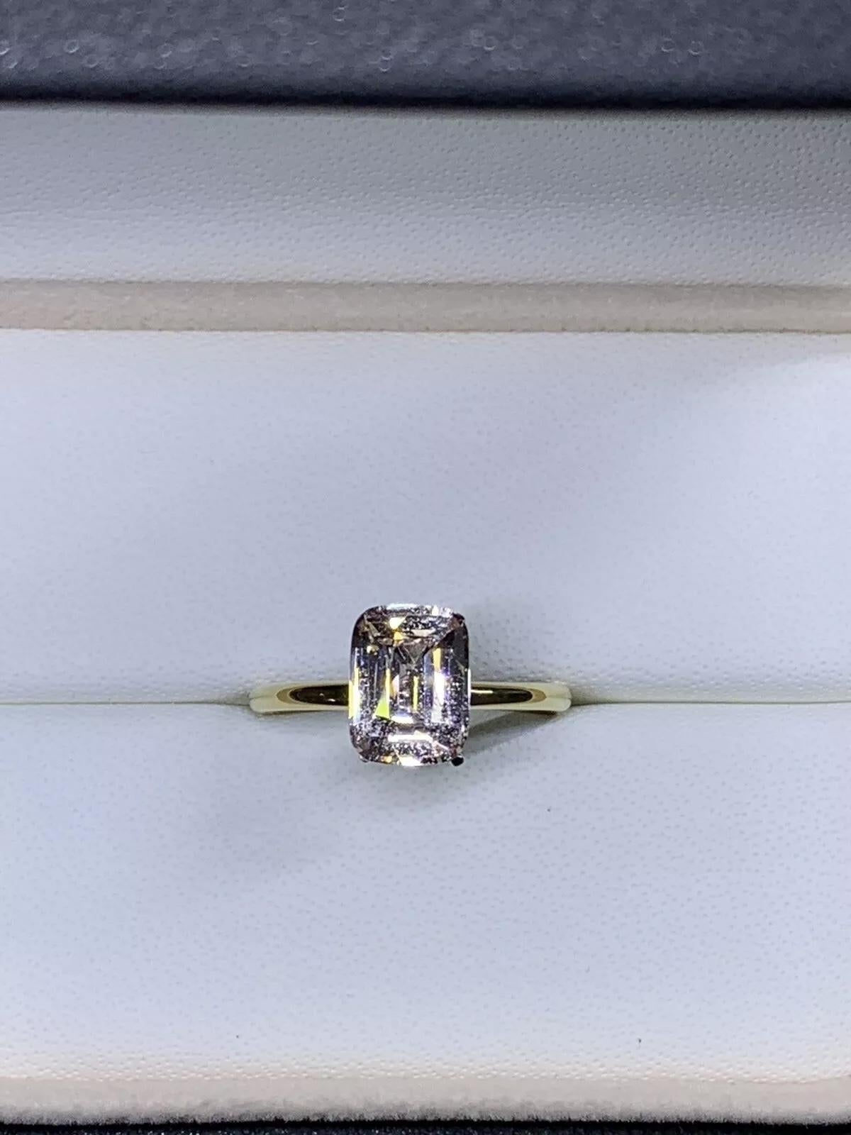 Cette superbe bague de fiançailles solitaire de 2,67 carats présente un magnifique saphir naturel de taille émeraude dans une monture classique en or jaune 18ct. Le saphir est complété par une pierre d'accent secondaire en saphir, créant ainsi un