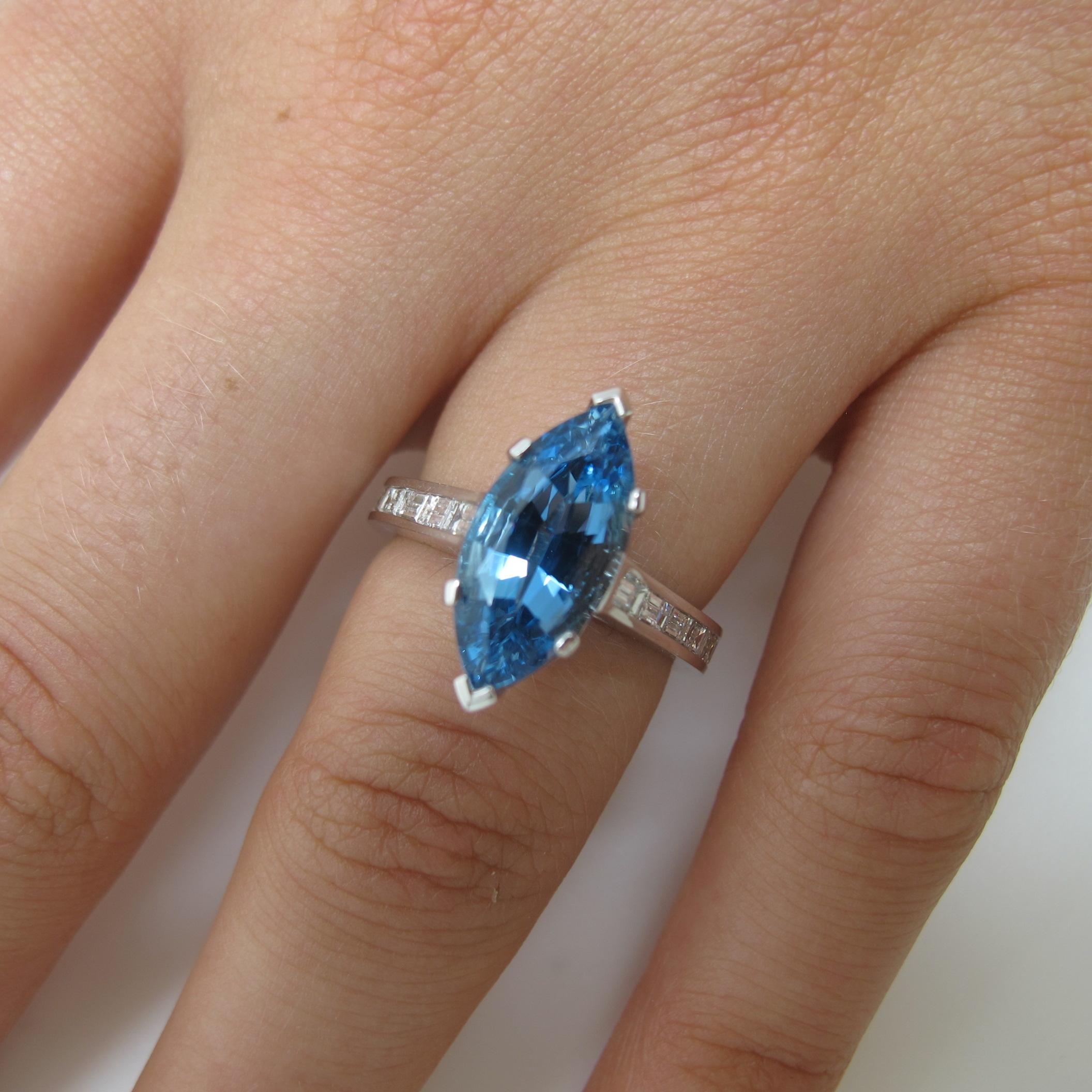 Seldom seen quality in aquamarine! This ultra dark blue stone is very rare, from the Santa Maria mine in Brazil. Marquise shapes are unusual in aquamarine. This one measures 14x7mm and weighs 2.68 carats.   Twelve baguette cut diamonds  with a total