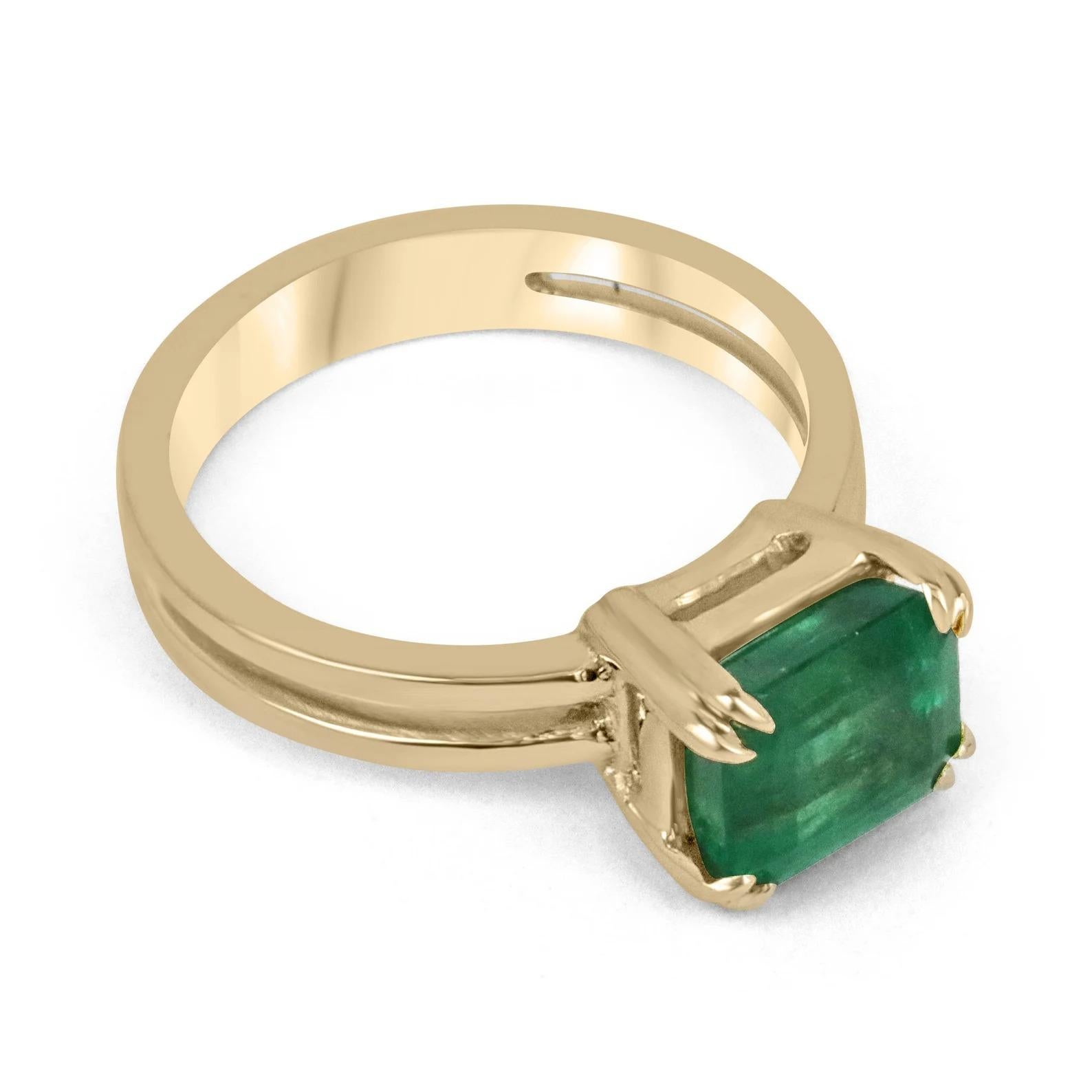 Displayed is a stunning East-to-West emerald solitaire engagement or right-hand ring in 18K yellow gold. This gorgeous solitaire ring carries a 2.68-carat emerald in a double-prong setting. Fully faceted, this gemstone showcases excellent shine and