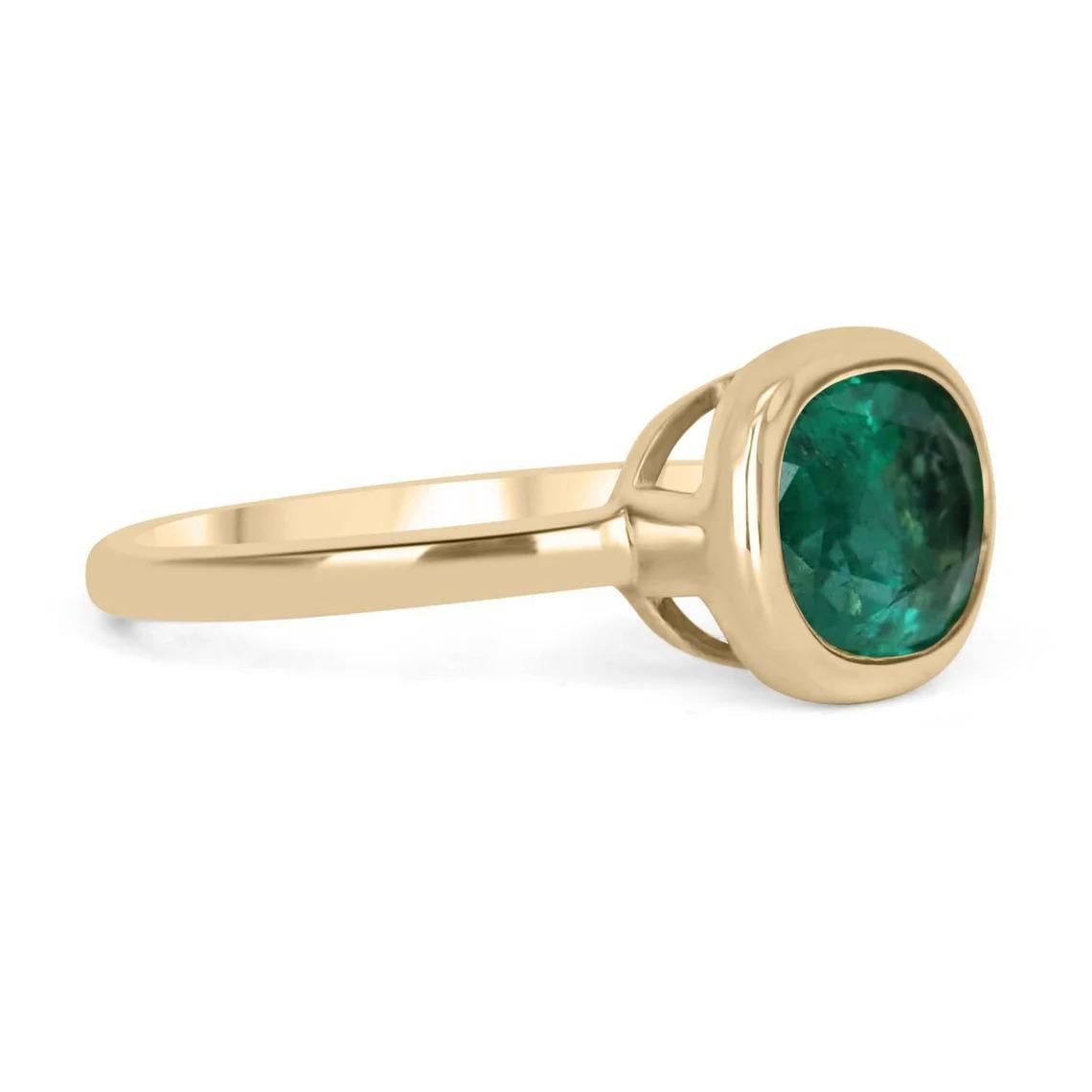 Displayed is a medium-dark green Colombian emerald, solitaire, oval cut bezel ring in 14K yellow gold. This gorgeous solitaire ring carries a full 2.68-carat emerald in a sleek bezel setting. The emerald has incredible clarity and luster. This