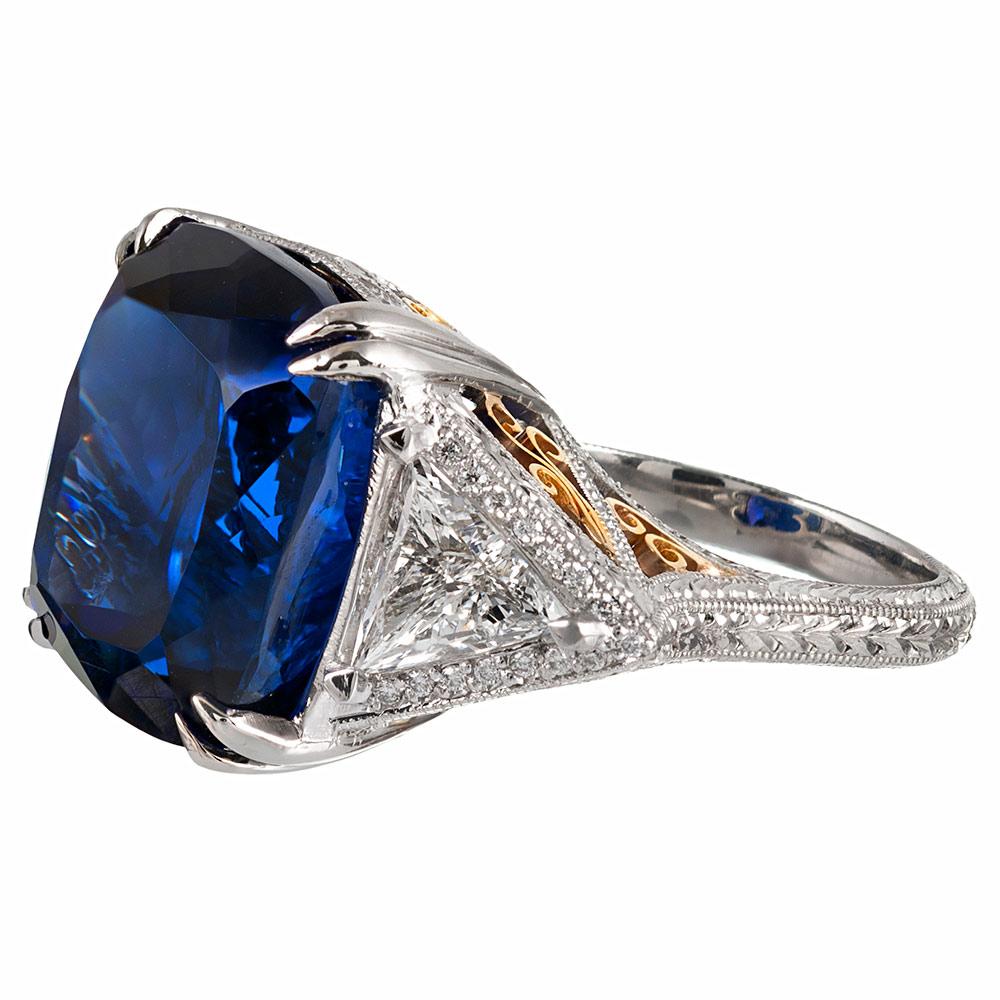 The elaborate platinum mounting with 18 karat rose gold accents was designed to compliment the important center stone, resulting in a most impressive creation. The tanzanite weighs 26.96 carats and exhibits exceptional intense royal blue color that